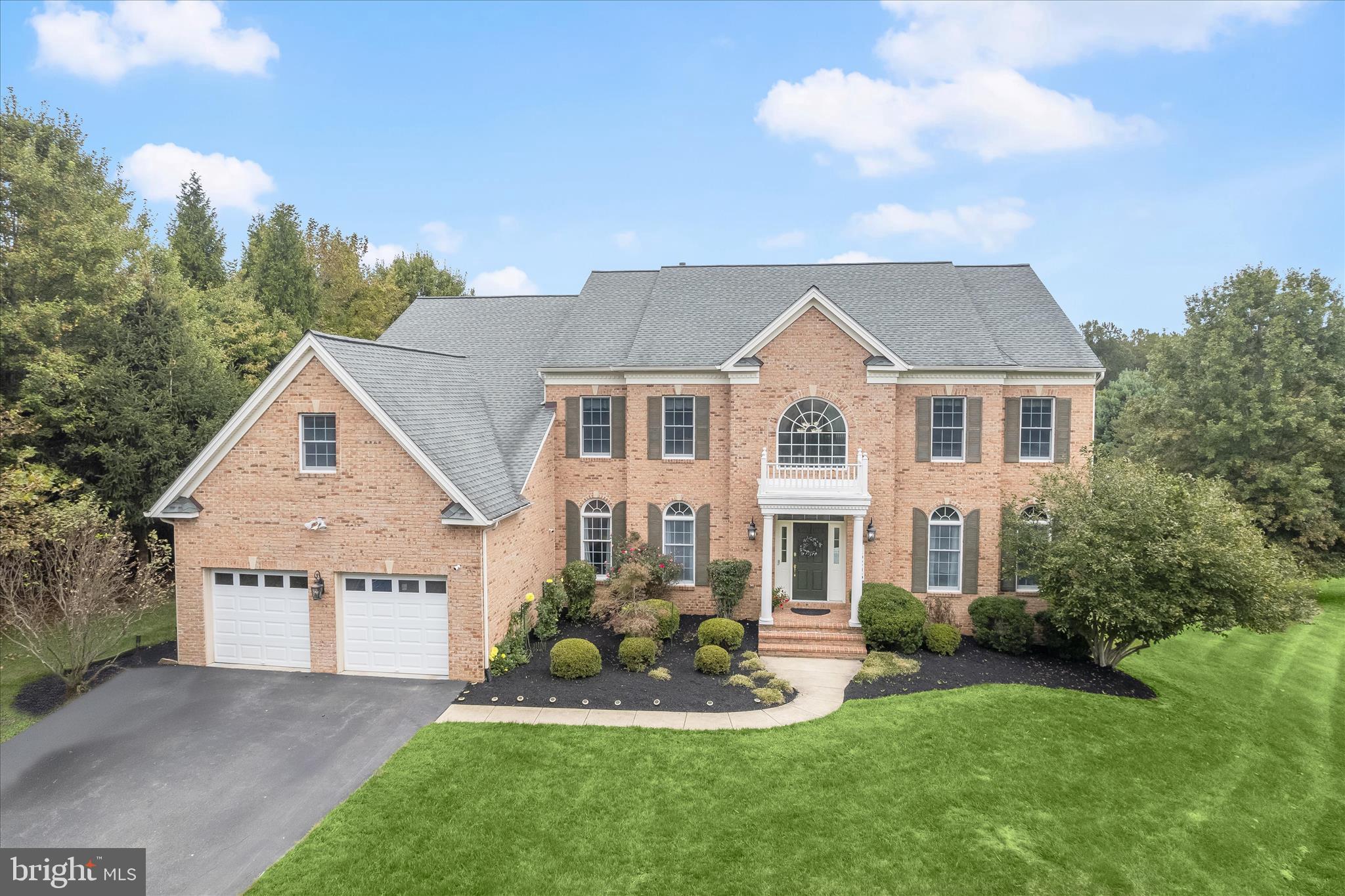 Experience the perfect harmony of grandeur, comfort, and seclusion in this stately Colonial residence, gracefully positioned on over an acre at the end of a peaceful cul-de-sac and framed by serene wooded vistas. With more than 6,000 square feet of impeccably crafted living space, this home embodies the finest in luxury living.  A dramatic two-story foyer welcomes you with sweeping staircases, architectural columns, and refined millwork, setting an impressive tone carried throughout the home. The formal living and dining rooms exude classic sophistication, enhanced by rich moldings and gleaming hardwood floors that lead into the heart of the home, a gourmet chef’s kitchen featuring an oversized granite island, custom cherry cabinetry, and premium stainless steel appliances. Seamlessly transition to the expansive deck with canopy, the perfect retreat for alfresco dining while overlooking picturesque, tree-lined views.  The sun-drenched two-story family room serves as a magnificent yet inviting gathering space, anchored by a soaring wall of windows and a stunning wood-burning fireplace with a brick surround. Thoughtful main level amenities include a home office, an elegant powder room, and a spacious laundry/mudroom with granite countertops, abundant cabinetry, utility sink, and direct garage access.  Upstairs, the luxurious primary suite offers a private sitting room, an expansive 26 x 10 ft walk-in closet and a 2nd walk-in closet , and a spa-inspired bath with soaking tub, separate shower, and dual vanities. Each of the three additional bedrooms enjoys a private en suite bath, offering unparalleled comfort and privacy.  The fully finished lower level is an entertainer’s haven, complete with a recreation room, game room, and a dedicated media room with built-in speakers and projector, and a second home office. Two versatile bonus rooms, a full bath, two unfinished storage areas, and a wide walk-up to the scenic backyard complete this remarkable level.  Outdoors, enjoy resort-style living on the sprawling deck and stone patio, surrounded by lush landscaping and tranquil wooded views, your private sanctuary for relaxation or elegant entertaining. A whole house generator and two EV charging outlets provide modern convenience and peace of mind. A two-car garage and extended driveway offer ample parking.  Perfectly situated near premier dining, shopping, entertainment, and major commuter routes, this exceptional home seamlessly combines refined luxury with everyday convenience, an exquisite retreat for those who expect the very best.