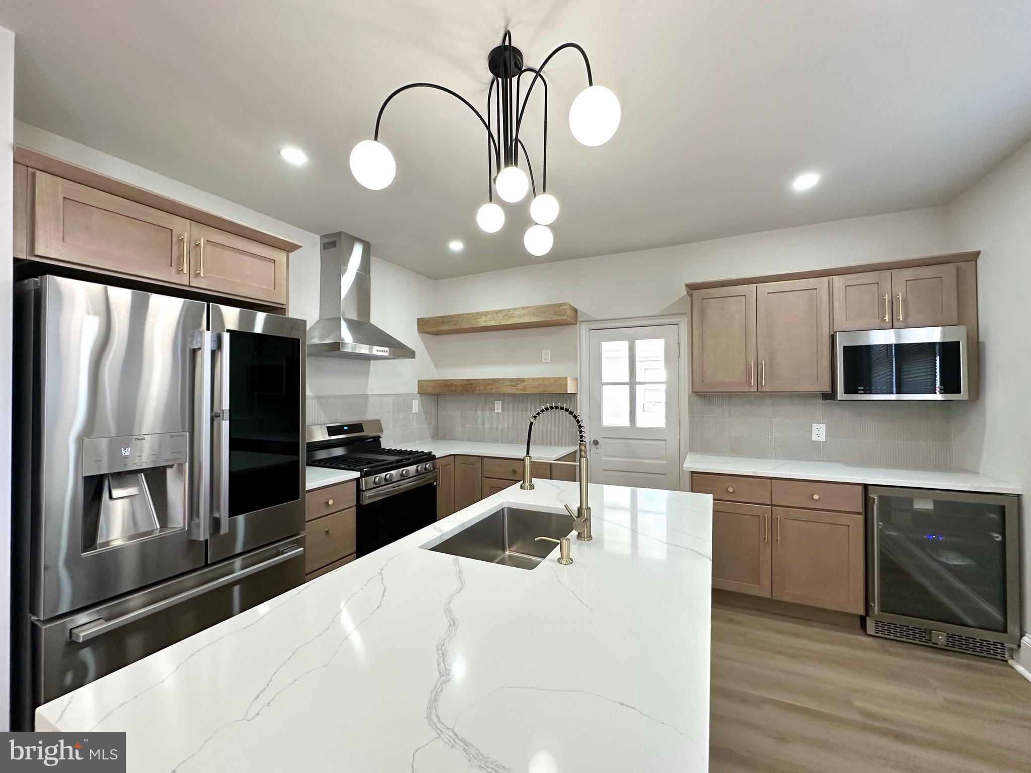 Rare opportunity to own this unique, corner End- unit property with attached garage! Elegantly rehabbed with contemporary finishings while keeping the vintage charm of Philadelphia’s original townhome. Walking  through the enclosed porch, features an open floor plan with soaring natural lights, orginal hardwood floors, and new recessed lighting throughout. Enjoy an updated living room with modern light fixtures and cozy fireplace, providing extra warmth to this beautiful space. Completely renovated kitchen outfitted with brand new island with waterfall quartz countertop,  a beverage station, equipped with luxurious stainless steel appliances, antique brass fixtures and soft closing cabinets. The main living area features wainscoting for an upscale look, an accessible 1/2 bath and easy access to the expansive back,  side  yard perfect for outdoor gatherings and garden. The fully finished basement provides access to the attached heated garage and private secluded office space. The upper floors has 3 spacious bedrooms and 2 full baths, including  a master bedroom with private master bath. Lovely neighborhood with the postal service around the corner. Contemporary contrasted with vintage charm, this is a design dream home!!