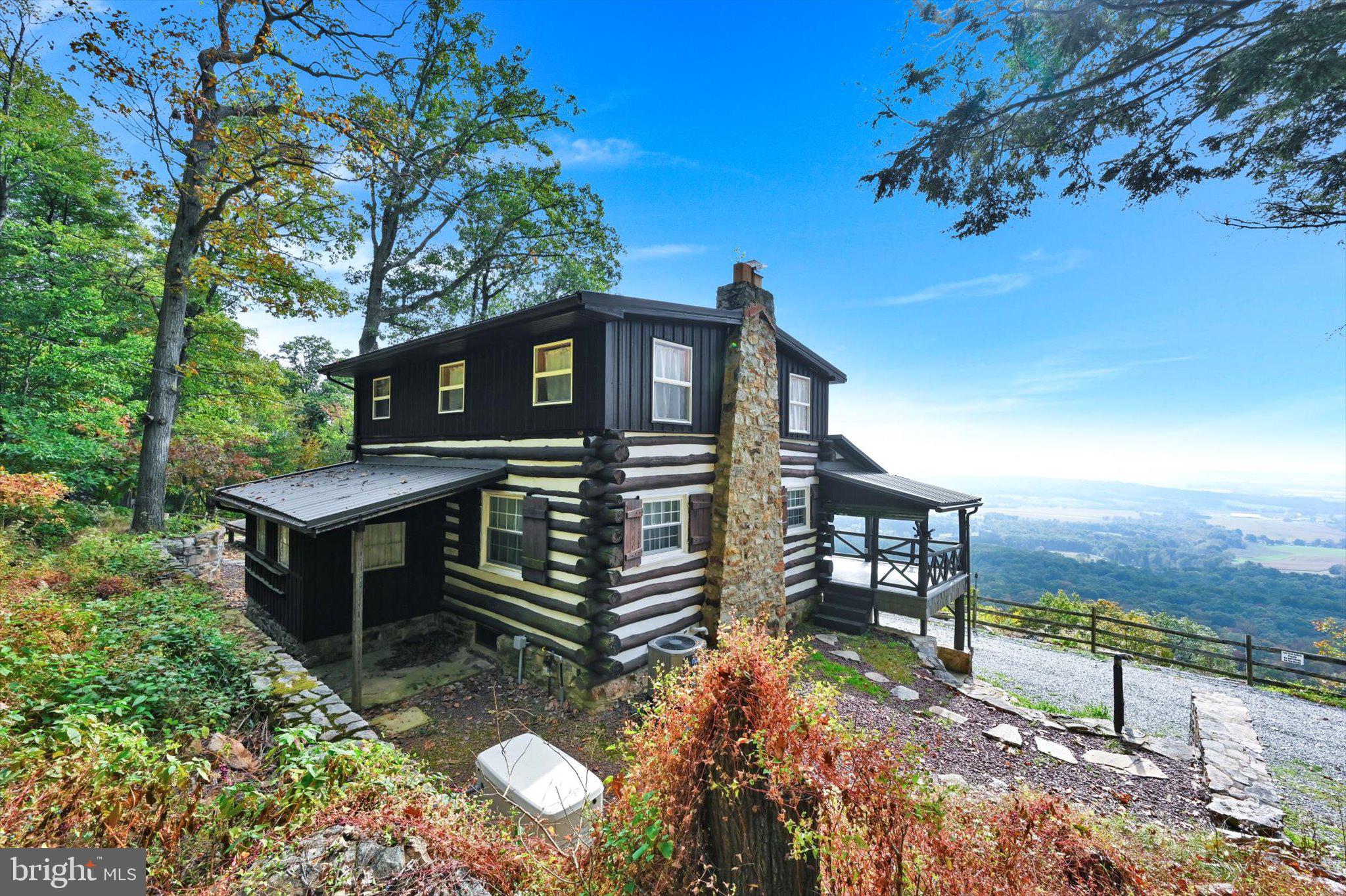 Public Auction Nov 17 2023, 2PM - Open Houses Saturday, October 28 1-3 PM and Saturday, Nov 4th 1-3 PM * Successful bidder required a 10% non refundable deposit - Settlement within 45 days - Buyer pays the 2% real estate transfer tax - List price does not reflect final sales price. A Mountaintop Experience! This captivating, tastefully remodeled 3Bed 2Full Bath "getaway" sits on 9.4 acres high atop the Blue Mountain; delivering truly breathtaking southern views of the farmland tapestry below! With its neatly crafted log charm and appealing classic upper/lower porches offering unmatched views, this home affords a tranquil enjoyment of the mountain breezes and panoramic sky that will chase away the cares of the world below. Inside you'll find a totally furnished home selling with all its furniture that presents a wonderful blend of primitive and modern style in the fully renovated array of timeless exposed log and stone walls, open beams, delightful tongue and groove ceilings, massive mountain stone FP with insert, pristine stone countertops, stainless appliances, oversized farmers sink, owners suite with soaking tub and walk in shower and crisp ceramic plank floors all served up with the utmost care and in a tastefully understated palette of colors. With a fully finished walk-out lower level guest suite and hidden laundry, there are 3 floors of enjoyment and discovery in a home that can serve as a primary residence and vacation retreat with equal ease! New mechanicals like a the propane hot air furnace and central air and 22 KW generator with 1000 gallon propane tank will help the focus to be on enjoyment and exploring the natural setting and attractions like the Appalachian trail itself (only a short walk away) and other wider trails that run the ridge all the way to Hawk Mountain! Imagine experiencing all this enjoyment and serenity only minutes from major PA routes! Come share this powerful experience and make this special offering yours! Reserved items : WIFI hotspot and 2 security cameras.