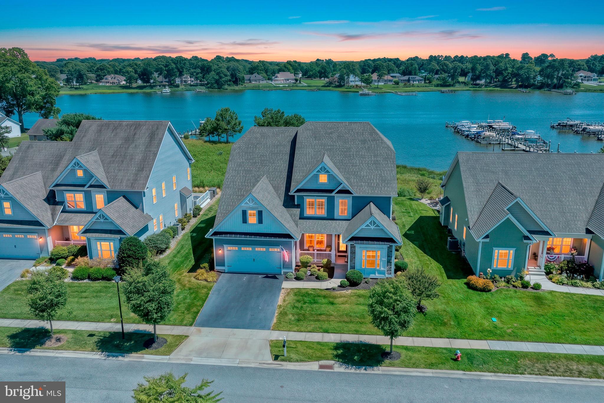 Welcome to Marina at Pepper's Creek, where luxury waterfront living meets exceptional coastal convenience. This stunning Insight Homes Peterman model offers 3,945 square feet of beautifully designed living space with breathtaking views of Pepper's Creek and the Indian River Bay from two expansive waterfront decks. An incredible opportunity awaits with the optional purchase of a deeded boat slip with lift and a 2024 Starcraft Tritoon boat, making it easy to embrace the boating lifestyle from day one.

A charming front porch welcomes you into the foyer, where a formal dining room sits to the left and two guest bedrooms sharing a full bath are privately located to the right. Straight ahead, the dramatic two-story great room showcases soaring ceilings, walls of windows framing spectacular water views, a gas fireplace, and luxury vinyl plank flooring. The adjoining sunroom opens to the spacious rear deck, creating the perfect setting for relaxing or entertaining while enjoying the tranquil waterfront scenery.

Designed for both everyday living and entertaining, the open-concept floor plan seamlessly connects the great room, gourmet kitchen, and casual dining area. The kitchen is beautifully appointed with white cabinetry, granite countertops, stainless steel appliances, a tile backsplash, a center island, and a pantry. Convenient access to the laundry room with utility sink and the attached garage adds everyday functionality.

The first-floor owner's suite is a peaceful retreat featuring a spacious walk-in closet, an additional closet, and a luxurious ensuite bath with a large tiled shower, dual granite vanity, and elegant finishes. Also on the main level is a fourth bedroom, currently used as a home office, providing flexible living space.

Upstairs, a spacious family room with a wet bar opens to the second-level waterfront deck, where a retractable awning and spiral staircase provide easy access to the lower deck. The upper-level owner's suite features its own private bath with a tiled shower and granite vanity. Two additional bedrooms share a Jack-and-Jill bath with a double vanity and tiled shower. A large unfinished storage room offers outstanding potential to create an additional bedroom, media room, or bonus living space.

Numerous upgrades enhance the home's comfort and convenience, including a stairlift, irrigation well for the lawn irrigation system, custom blinds and window treatments, a security system with exterior cameras, smart home technology, and a reverse osmosis drinking water system at the kitchen sink.

Boating enthusiasts will appreciate the opportunity to purchase deeded Boat Slip #30, complete with a lift, for $65,000. Also available separately is a like-new 2024 26-foot Starcraft Tritoon powered by a 300 HP engine with low hours and custom cushion covers for $102,000. Spend your days cruising to Paradise Grill for waterfront dining or heading through the Indian River Inlet for world-class fishing and adventures on the Atlantic Ocean.

Marina at Pepper's Creek offers resort-style amenities, including a community pool, clubhouse, fitness center, and private boat ramp for launching boats, jet skis, kayaks, and paddleboards. This is a rare opportunity to enjoy the very best of Delaware's waterfront lifestyle—whether you're entertaining on the deck, spending the day on the water, or simply soaking in the panoramic views from home.