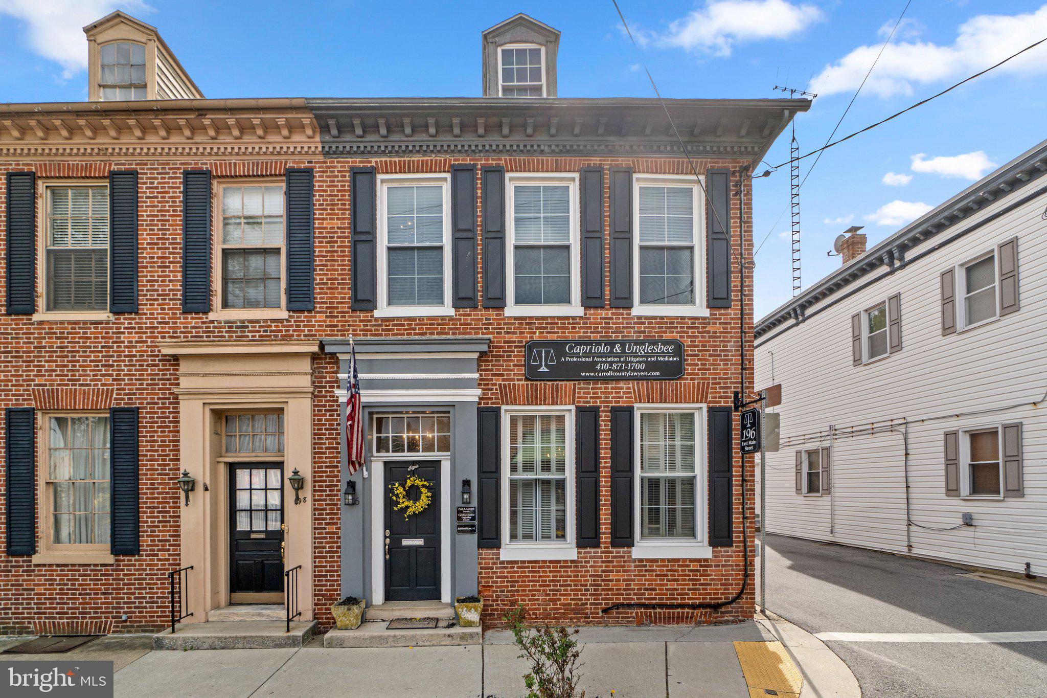 Prime Commercial/Potential Residential Office/Home with Private Rear Parking | 196 E. Main St., Westminster, MD 21157. Exceptional end-unit rowhome in the heart of downtown Westminster! This versatile commercial property offers 4/5 private offices/bedrooms, including 1 on the main level, 2 bathrooms, and 2 entrances— 1 of which is handicap accessible with designated handicap parking. Situated just 1 block from the old historic courthouse and 3 blocks from the main courthouse, the location is ideal for legal, professional, medical offices, or small business. Enjoy the enduring charm of exposed brick accent walls, permanent stone foundation, and classic architecture, blended seamlessly with modern amenities including central A/C, natural gas heat, and a private 10-spot paved parking lot—a rare downtown find. Recent upgrades include a new HVAC system (2023), newer windows (2017), and water heater (2017). Additional dry attic and basement storage provide ample room for files, supplies, or equipment. Walkable to restaurants, shops, and local businesses—this is a unique opportunity to own a character-rich, highly functional office space in one of Westminster’s most desirable commercial corridors.