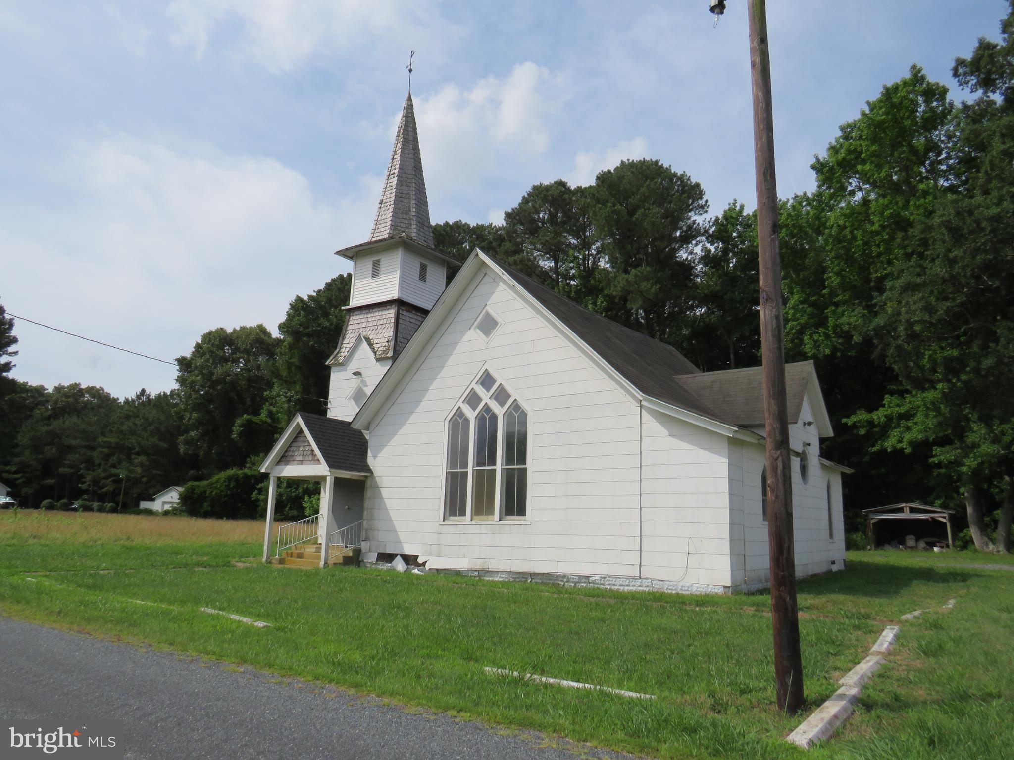 Have you dreamed of converting a church to a dwelling?  Here is your chance!  Frame built country church, built in 1890,  on a one acre lot has a lot of possibilities.  Large open sanctuary area has pine floors with carpeted walkways, beadboard vaulted ceiling,  Stained glass windows are in the sanctuary area.  There are two  powder rooms, oil fired hot air heat, and window air conditioners.  This building is sold "as is". There are some evident structural issues.   The newer white storage building will be removed from the property.