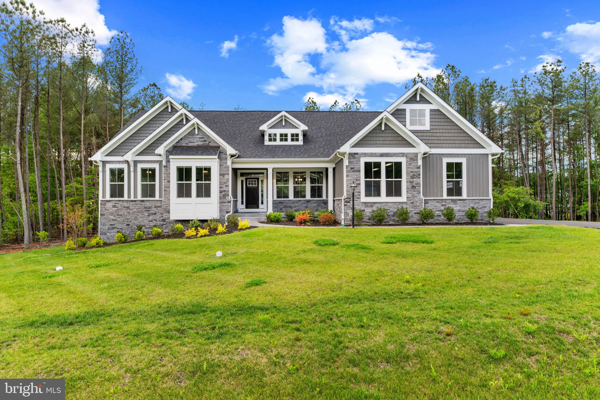 HUGE PRICE REDUCTION! Nestled in the prestigious Pinehurst subdivision, this exceptional Craftsman-style estate—completed in 2025 and maintained in immaculate, like-new condition—offers the perfect blend of refined luxury, modern technology, and peaceful rural living. Situated on over an acre with mature trees bordering two sides, this stunning residence provides a private retreat within a pristine newer community, available only due to military relocation.

From the moment you arrive, the home’s impressive curb appeal and custom exterior upgrades set the tone. Professional landscaping, an in-ground sprinkler system, custom concrete work, and a private asphalt driveway create a polished first impression—but the true showpiece is the extraordinary oversized 4-car garage with a massive RV bay. Designed for collectors, hobbyists, adventurers, or anyone needing exceptional storage and workspace, this fully finished garage features custom epoxy flooring, upgraded lighting, and room to accommodate your largest vehicles, recreational equipment, or workshop dreams.

Inside, over 3,900 square feet of thoughtfully designed living space showcases timeless craftsmanship paired with sophisticated modern finishes. The sun-drenched open-concept floor plan is ideal for both entertaining and everyday living, enhanced by crown molding, luxury vinyl plank flooring, and expansive windows framing serene wooded views.

The gourmet kitchen is a culinary centerpiece, outfitted with premium ENERGY STAR stainless steel appliances, a 36-inch gas cooktop, dual ovens, abundant prep space, and a dedicated reverse osmosis water system. Seamlessly connected to the dining and family rooms, the space invites effortless gatherings both large and intimate.

The luxurious primary suite serves as a private sanctuary, complete with expansive custom walk-in closets by Closets by Design and a spa-inspired bath featuring dual vanities, a soaking tub, and an oversized shower with dual shower heads.

Downstairs, the entertainment possibilities reach another level with a truly world-class private cinema that rivals commercial theaters. Enjoy an immersive experience with a 130-inch screen, 8K projector, tiered stadium seating, and a professionally calibrated 9.4.4 Dolby Atmos surround sound system with DIRAC active room treatment. The expansive lower level also includes a large recreation area, two oversized storage rooms, and incredible future potential with two additional bedrooms and a bathroom already framed and plumbed for completion.

Modern infrastructure and efficiency further elevate the home, including a private well and septic system, whole-house water softener, energy-efficient windows and insulation, high-speed internet wiring, and a comprehensive security camera network.

Offering luxury, privacy, cutting-edge entertainment, and one of the most impressive garages on the market, this extraordinary property presents a rare opportunity to own a fully upgraded custom estate without the wait of new construction.