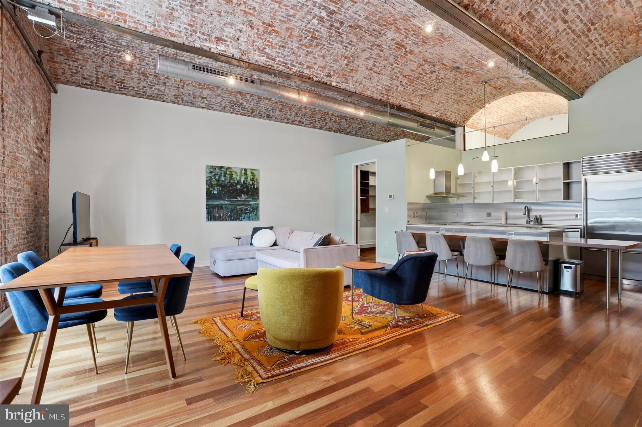 Experience unparalleled loft living in Residence #401 at The White Building, an exceptional 4th floor residence with a private hallway shared by only one other unit. The White Building is a rare, design-forward loft in one of Philadelphia’s most coveted neighborhoods.  This dramatic open loft showcases a striking blend of industrial character and refined luxury, featuring exposed brick walls, soaring 16-foot barrel vaulted brick ceilings, and impressive 9-foot arched windows that flood the space with natural light. Rich Brazilian cherry hardwood floors and solid core doors further elevate the home’s sophisticated aesthetic. The chef-inspired kitchen makes a striking statement, appointed with sleek Pedini stainless steel cabinetry, a touch less faucet, and under-cabinet lighting. A full suite of premium stainless steel appliances elevates the space, including a Sub-Zero refrigerator, Bosch stove, microwave, dishwasher, and a five-burner induction cooktop with a stainless steel hood. Carrera white marble countertops, a metal backsplash, generous pantry storage, and an expansive island complete this exceptional culinary space. Thoughtfully designed for both style and function, this unit also features a custom California walk-in closet and an in-unit Bosch washer and dryer. The spa-like bath offers a luxurious retreat with a deep soaking tub, custom glass-enclosed shower, and elegant stone accents throughout. The White Building is a boutique, pet-friendly residence offering modern conveniences, including a state of the art virtual concierge, coded elevator, secure mailroom, and a fitness center.  Ideally located in the heart of Midtown Village, the location offers a vibrant, unmatched urban lifestyle, just minutes from premier grocers, artisanal coffee shops, and multiple fitness studios.