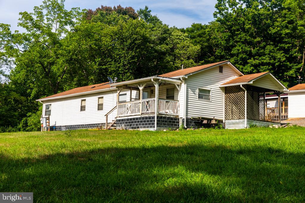 Property back on market at not fault to Seller.  This is your chance to own a Nice Property In The Country with PUBLIC WATER  and FIBER OPTIC internet.  Two homes containing a total of 7 Bedrooms and 2 Bathrooms.  Primary house is singlewide with 3BR and 1 Bath and two additions.   Secondary house is single wide with large addition and has 4 BR , 1 Bath and large living room area.  Nice garage on poured concrete floor located between the houses.  Large graveled parking area.  Newer shingle roof on first house and metal roof on second house.  This is a well maintained property and is partially furnished. 
Property has been used as vacation home and hunter lodging as well as a residential rental.  Get back to your roots with great country living.  Room for all your hobbies, gardening and enjoying nature.  Contact me today for more information and a showing.