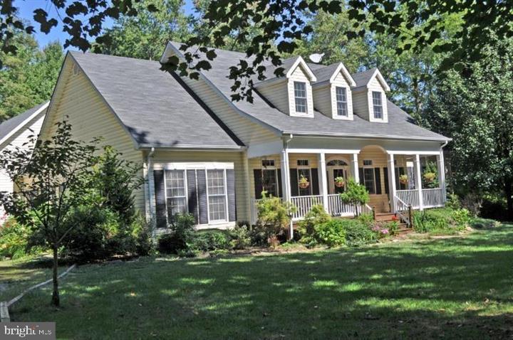 Charming Cape Cod on 2  acres.  This beautiful home is one level living at its finest!  A lovely covered porch greets you upon arrival, this porch is the perfect space for enjoying morning coffee or just relaxing in the evening after a long day.   Inside you will love the Open floor plan and the vaulted ceilings in the family room with a cozy wood burning fireplace and a wall of windows with natural light pouring into the space .  This is the perfect home to entertain friends and family with an abundance of space inside and outside of the home. 
 The main level consists of an updated eat in kitchen with an abundance of cabinet space, a formal dining room, a delightful  Primary Suite with  sliding doors leading to the  oversized deck, ensuite bath with a large soaking tub , shower stall and 2 walk-in closets.   Three additional bedrooms, one full bathroom, a laundry room, mud room and powder room complete the main level.  There is fresh paint throughout the home and the bedrooms have new carpeting,  the bathrooms, laundry room and mud room have new LVP flooring.  The upper level has a huge loft that can be used as an 5th bedroom/office/rec room.  If you like to entertain you are going to be excited about the oversize deck in the rear that is partially covered and overlooking a big beautiful yard.  Lower level walk out unfinished basement with a wood stove has plenty of space for rooms and just waiting for your design ideas. Home Warranty included.