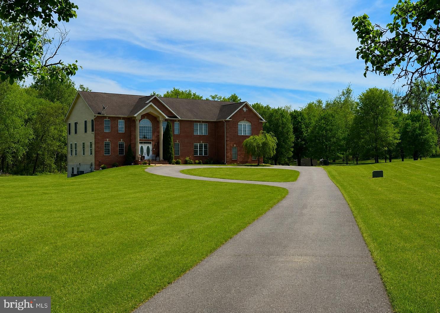 Opportunities like this rarely come to market. Nestled on 10.82 breathtaking private acres in the prestigious The Hills Over Mullikan Station community, this stately brick-front Colonial offers an extraordinary combination of privacy, space, and convenience. Known for its estate-style homes on expansive homesites, this sought-after community provides a peaceful retreat while remaining just minutes from shopping, dining, entertainment, schools, and major commuter routes.

Surrounded by mature trees and natural beauty, the property creates a sense of tranquility rarely found this close to Washington, D.C. Inside, a thoughtfully designed floor plan blends elegant entertaining with comfortable everyday living. Upgraded flooring installed throughout the main level, staircase, and upper hallway in 2022 creates a seamless flow, while the dramatic dual staircase makes a lasting first impression.

The home features a formal living room, elegant dining room, private office, and spacious family room with fireplace. The expansive primary suite serves as a private retreat with a dual-sided fireplace, soaking tub, and separate shower. A private en-suite bath in the third bedroom is ideal for guests or multigenerational living. The finished lower level provides flexible space for recreation, fitness, hobbies, or a media room, while laundry facilities on both the main and lower levels add convenience.

Recent improvements include upgraded flooring (2022), UV water filtration system (2022), radon mitigation system (2022), Culligan water softener (2023), propane tank (2023), new upstairs dishwasher, professionally inspected well pump, new well pressure tank (2026), and primary bedroom carpet replacement (2022). The side-load four-car garage offers abundant room for vehicles, hobbies, equipment, and storage.

Beyond the property, enjoy everything Bowie has to offer. Nearby Allen Pond Park features walking trails, paddle boats, fishing areas, playgrounds, and seasonal events, while Watkins Regional Park offers a miniature train, carousel, nature center, athletic fields, and expansive playgrounds. Residents enjoy popular community traditions including the Sunday Summer Concert Series, Bowie Beats & Brushes, and the City of Bowie Memorial Day Parade.

Shopping, dining, and entertainment are minutes away at Bowie Town Center, with local favorites including Jerry's Seafood, Rip's Country Inn, Old Bowie Town Grille, Carrabba's Italian Grill, and LongHorn Steakhouse. Families will appreciate access to Bowie High School's Advanced Placement and gifted programs, along with nearby public and private school options.

Conveniently located near Route 50, Route 301, Route 197, and MARC Train service, this property offers easy access to Washington, D.C., Annapolis, Baltimore, and Fort Meade while providing the privacy and serenity that make this location so special.

Properties in The Hills Over Mullikan Station rarely become available, and opportunities to own more than 10 private acres in Bowie are exceptionally limited. Whether you envision hosting unforgettable gatherings, creating a multigenerational retreat, or simply enjoying the peace and freedom of your own private estate, this remarkable property offers a lifestyle that is truly difficult to replicate.

Property is occupied. Please do not enter or walk the property without a confirmed appointment.