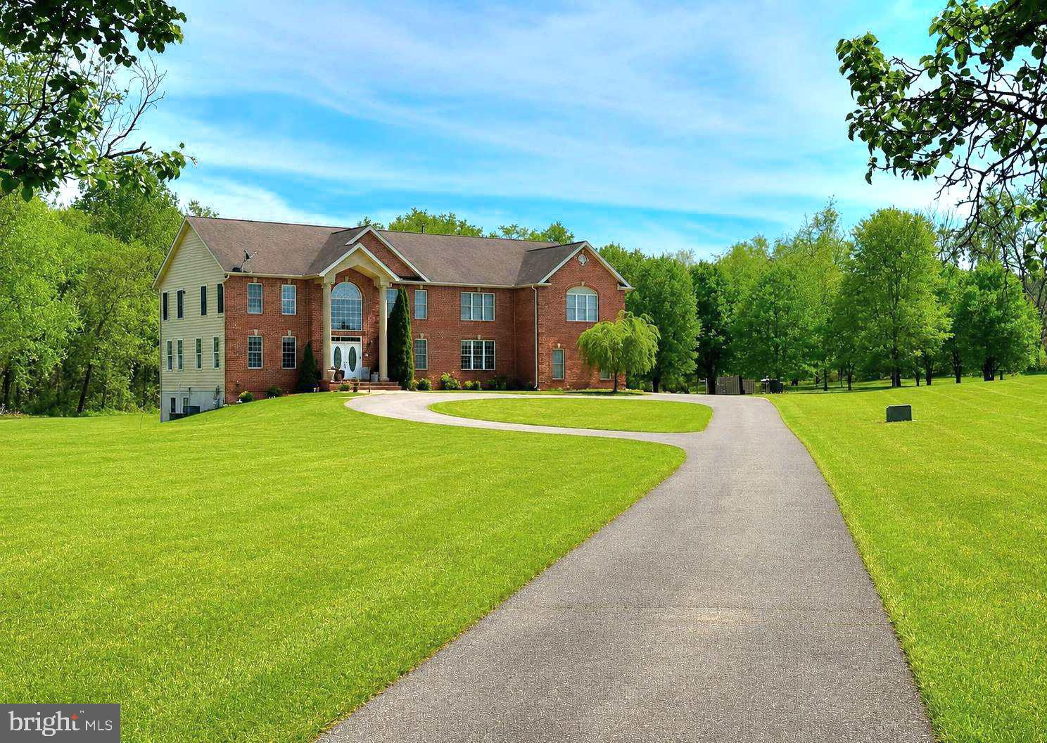 Imagine owning more than 10 private acres just minutes from Washington, D.C., a place where mornings begin surrounded by mature trees, where there is room to gather the people you love, and where privacy, space, and freedom become part of everyday life. Welcome to 16619 Peach Street, a remarkable 10.82 acre private estate offering 6,820 square feet, 7 bedrooms, 5.5 baths, and a four car garage in The Hills Over Mullikan Station. Opportunities to own this much land in Bowie are exceptionally limited, offering extraordinary privacy without giving up access to the places you need to be. Here, the land is not simply acreage. It is part of the lifestyle. Picture quiet mornings surrounded by nature, long afternoons enjoying your own private outdoor space, children and pets with room to explore, gardens growing season after season, and unforgettable gatherings beneath open skies. Whether your vision includes outdoor recreation, expanded gardens, walking paths, additional outdoor living spaces, or simply preserving the natural beauty and privacy already here, 10.82 acres gives you the rare freedom to imagine life on a much larger canvas. Any future improvements or uses should be independently verified for zoning, HOA, permitting, environmental, and other applicable requirements. A long approach leads to the stately brick front Colonial, creating an immediate sense of arrival. Inside, a dramatic dual staircase introduces an expansive floor plan designed for both everyday living and memorable occasions. Formal living and dining rooms provide elegant settings for holidays and celebrations, while a private office offers dedicated space to work or study from home. The spacious family room with fireplace is made for gathering, unwinding, and reconnecting. Upgraded flooring installed throughout the main level, staircase, and upper hallway in 2022 creates a cohesive flow. The expansive primary suite is a private retreat with a dual sided fireplace and an adjoining bath featuring a soaking tub and separate shower. Additional bedrooms offer flexibility for family, guests, work, hobbies, or multigenerational living, including a third bedroom with its own private en suite bath.

The finished lower level expands the possibilities with flexible space for recreation, fitness, hobbies, entertainment, or a media room. Laundry facilities on both the main and lower levels add convenience, while the side load four car garage provides exceptional capacity for vehicles, equipment, hobbies, and storage.
Thoughtful improvements include upgraded flooring and primary bedroom carpet replacement in 2022, a UV water filtration system and radon mitigation system in 2022, a Culligan water softener and propane tank in 2023, a new upstairs dishwasher, a professionally inspected well pump, and a new well pressure tank in 2026. The property feels worlds away from the pace of everyday life yet remains connected to the best of the region. Bowie Town Center, dining, parks, recreation, schools, and everyday conveniences are within easy reach. Nearby Allen Pond Park and Watkins Regional Park provide additional opportunities for trails, recreation, community events, and outdoor enjoyment.
Convenient access to Rt. 50, Rt 301, Rt 197, and MARC Train service creates connections to D.C., Annapolis, Baltimore, Fort Meade, and surrounding employment centers. This is more than a large home on a large parcel. It is the opportunity to create a private world of your own, one with room for family, celebrations, quiet, nature, and the life you have been waiting to live. For the buyer searching for something that cannot be easily duplicated, 16619 Peach Street offers a rare combination of 10.82 private acres, nearly 7,000 square feet of living space, 7 bedrooms, a four car garage, and access to the Washington metropolitan region, all in one extraordinary Bowie estate. Property is occupied. Please do not enter, walk, or access the property without a confirmed appointment.