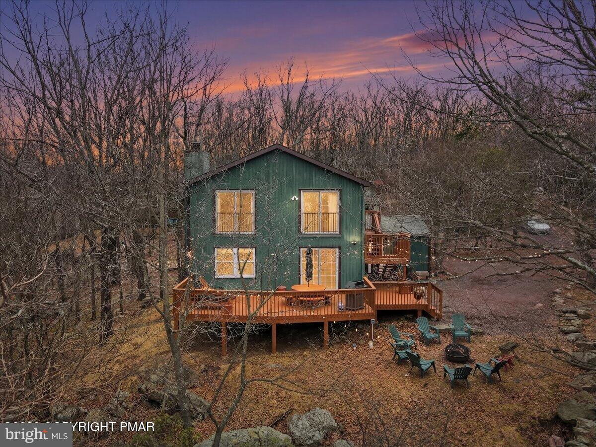 Perched on a private ridge in sought-after Lake Harmony Estates, this 4BR/2BA mountain retreat offers breathtaking views of Big Boulder ski slopes from multiple levels. Tucked on the quiet dead-end street of Hidden Ridge, the home provides privacy while being minutes to Lake Harmony’s private beach, motor boating, skiing, golf, and year-round Pocono attractions. Designed for vacation living, the home features two kitchens, multiple living areas, cozy fireplaces, and a spacious deck perfect for gathering with family and friends while enjoying sunset mountain views. The primary suite includes a jacuzzi tub, shower, and sauna for a true four-season escape. Being sold fully furnished and ready to enjoy, with public sewer (rare in the Poconos) and approved plans to expand to 8 bedrooms. A rare opportunity to own a scenic Pocono getaway in a premier lake and ski community.