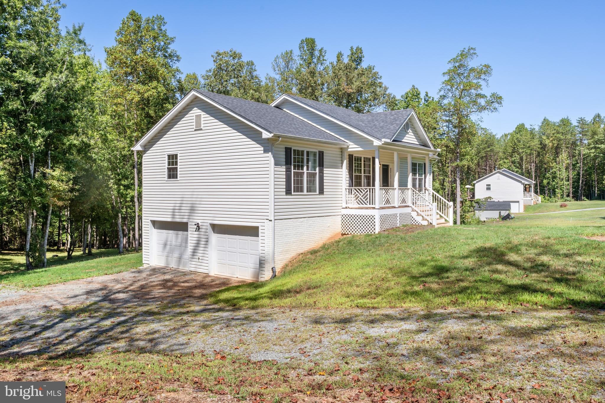 Peaceful country living on more than 2.5 acres. Close to Lake Anna and Blue Ridge Shores. This 3 bedroom, 3 bath, 2 car garage, 2054 sq ft bright and inviting home has plentiful natural light. Built only 4 years ago, you will love the beautiful oak hardwood floors, the lofty 9' and vaulted ceiling, a spacious open floor plan that features main level living with laundry hookups on both levels. Stainless steel kitchen appliances compliment the granite counter tops, plus a convenient movable kitchen island or coffee bar. A deck off the dining space is perfect for entertaining or simply unwinding and enjoying the view of the property. The lower level boasts outdoor access and a relaxing fireplace plus a wall of windows to enjoy watching nature change with the seasons. There is also a large laundry room, storage, a full bath, and access to the 2 car garage. No need to fear power outages with the generator interlock switch! Stepping outside, enjoy the open lush yard, the park-like setting with shade trees, the private firepit, the tree house, a meandering trail throughout the property, the spring, the seasonal creek, and enough space to do some hunting. Start your own homestead with the rich soil of the 2000+ sq ft organic garden and room for a variety of animals. This beautiful home won't last long!
