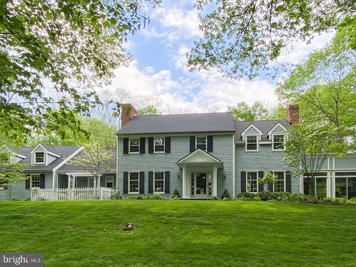 Welcome to Wildwood! Nestled on 11+ acres - making it one of the largest properties in New Hope - this exceptional home blends timeless traditional elegance with contemporary additions designed by award-winning architect Ralph Fey.  And it's just minutes by foot from the heart of vibrant New Hope. The thoughtfully-designed floor plan is both sophisticated and welcoming.  A gracious central foyer sits between the lovely formal dining room that sets the stage for memorable gatherings, and the expansive living room featuring a stunning fireplace with a lovely mantel and stone surround. Off the living room is the grand sun room...an extraordinary space with three walls of windows, high coffered ceiling, a soaring gas fireplace and gorgeous tile floors featuring radiant heat. Here the indoors seems to blend with the extensively landscaped gardens, lawns, and woods. Also accessed through the living room is a bonus space, currently used as a bar, which could be reimagined as a library, office or an extension of the living room. A cozy family room is located off the foyer. Here is a walk-in wood-burning fireplace with an impressive wood beam mantle. French doors lead to the deck which extends across much of the back of the house. The large eat-in kitchen has a decorative fireplace,  French doors to the deck, laundry room and garage access, and a walk-in pantry.  The main floor also has an updated powder room with a barn-style sliding door. Upstairs are four bedrooms, one of which is currently being used as an office. The primary bedroom features an electric  fireplace, sitting area, walk-in closet, dressing area and an updated tile bath. Another outstanding feature of this wonderful home is the other Ralph Fey-designed addition - a suite accessed with its own set of stairs leading from the rear deck. Currently used as a guest suite with a gorgeous tile bath, a full kitchen and an outdoor seating area. The grounds of Wildwood are criss-crossed with woodland paths, hidden seating areas, lush planting beds with flowering shrubs and perennials,  several streams enhanced with recirculating pumps and attractive outdoor lighting. The grounds also feature a  flagstone patio with a propane fire pit that overlooks waterfalls and the koi pond.  Ideal for evening gatherings and watching sunsets. The backyard gardens are protected by an 8 foot deer fence and watered by an extensive sprinkler system. A large cottage-style garden house is ideal for storing equipment, tools and outdoor furniture and games. This extraordinary property is less than one mile from the center of New Hope with its charming shops, fine dining and cultural attractions, and is served by the highly-rated New Hope-Solebury School District. It is close to commuter routes with Philadelphia a 40 mile drive. The Holland Tunnel is a 68 mile drive. This is truly a remarkable offering in an unparalleled setting.