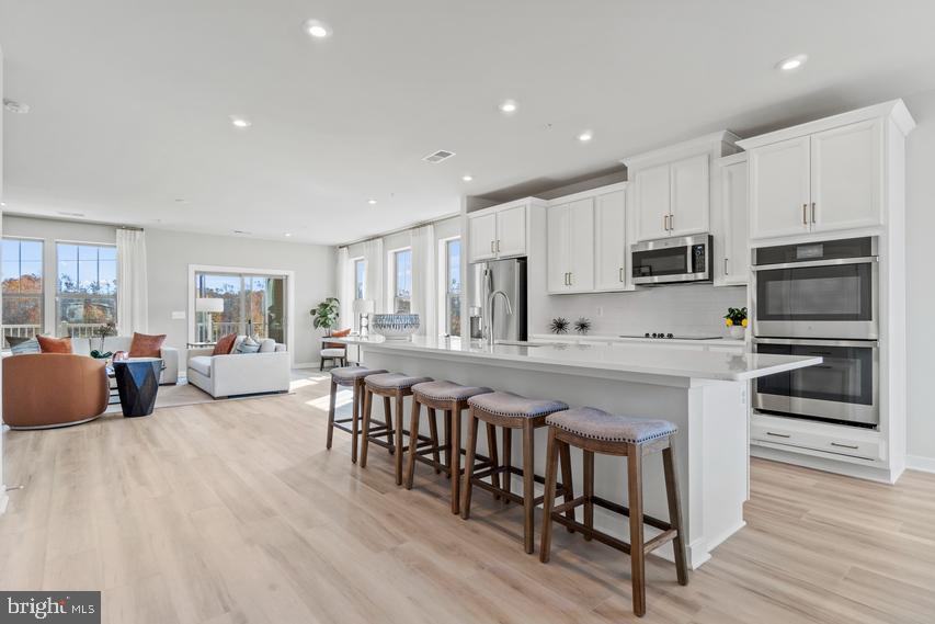 Brand new Stanley Martin end unit townhome-style garage condo facing the largest park in the neighborhood plus a rooftop terrace!
Step into this remarkable end-unit Julianne townhome-style condo, where you'll find a wealth of exceptional amenities and upgrades that cater to a truly elevated lifestyle. The main level showcases a gourmet kitchen adorned with stainless steel appliances and granite countertops, creating a culinary haven for any aspiring chef. The dining area provides an elegant space for enjoying meals, while a convenient powder room and private study add versatility to the floorplan. Step onto the covered balcony and take in the picturesque views of the neighborhood, offering a serene retreat right at home. Head to explore the inviting bedrooms, featuring a generously sized primary bedroom with a private en suite for ultimate relaxation. Two additional bedrooms share a well-appointed hall bathroom, providing ample space and comfort for all. But wait, there's more! For those seeking tranquility amidst breathtaking outdoor views, the spacious rooftop terrace awaits. Whether you desire a peaceful escape after a long day or an enchanting venue to host guests on warm summer evenings, this rooftop oasis offers the perfect setting. The photos shown are from a similar home. Contact us to schedule a tour or visit our model homes today!

Live within walking distance of the Silver Line Metro station, Innovation Center. Enjoy brand-new amenities dispersed throughout the neighborhood, including several pocket parks, a secluded meditation area, outdoor gathering spaces with an area for lawn games, a tot lot, and an open lawn exercise area. This location offers quick access to plenty of shopping, dining, and entertainment along with excellent Fairfax County Public Schools, including Coates Elementary which is a quick 0.3-mile walk from your front door. Also close to major commuting routes and some of the area's largest employers, living at Overlook at Dulles Tech is perfect for people who are looking to work and play close to home. Visit us today!