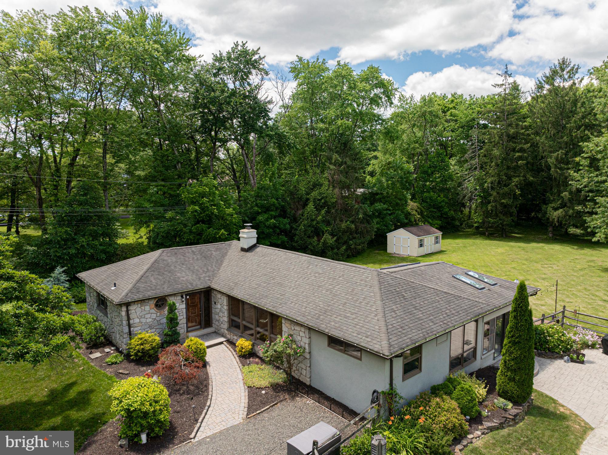 A Serene Mid-Century feel Ranch Retreat located in beautiful Schuylkill Township!  Travel down the driveway with me surrounding by beautiful green landscaping to a home, tucked away on a peaceful 1.1-acre property — thoughtfully spread across two separately deeded lots.  This striking stone ranch blends timeless modern design with contemporary updates and tranquil outdoor living. Mature landscaping surrounds, creating a lush, private sanctuary you will call your personal retreat! Step inside and you are immediately welcomed by the spacious, light-filled interior. A large formal living room with a stunning wall of windows flooding the space with natural light inviting you to take in views of the serene landscape beyond. The open-concept flow continues to the dining room and cozy side family room, both offering access to an impressive four-season room with vaulted ceilings, skylights, and year-round comfort thanks to heating and A/C.  Such a perfect space to gather, unwind, or simply enjoy the beauty of every season.  The heart of every home is the kitchen, and this beautifully updated galley kitchen provides you with an abundance of modern cabinetry and quartz countertops, Jenn-Air cooktop, and a double wall oven.  Beautifully designed to inspire everyday meals and memorable entertainment. Three generously sized bedrooms provide comfort and privacy, including a main suite with a fully tiled en-suite bath and spacious closet. A well-appointed hall bathroom offers a tub/shower combo, complementing the home's functional layout.  Hardwood floors flow seamlessly through this amazing home.  Outside, your backyard oasis awaits — complete with a sparkling in-ground pool, new pool equipment (including electric panel), and a stamped concrete patio ideal for lounging or lively summer afternoons. As day turns to night, imagine cozy gatherings around a firepit under the stars or swinging from a tree swing taking in all the peaceful sounds — pure magic. Additional features include a full, walkout waterproofed basement with three new sump pumps, a new well tank, new washer and dryer, updated 200-amp electrical service, newer HVAC systems (heater 2/23, A/C 5/20), hot water heater (6/23), and roof (2011) — ensuring peace of mind for years to come.  There is simply nothing to do but move in and begin your amazing summer in this fantastic home!  Perfectly located just minutes from schools, the YMCA, Valley Forge Park, Paoli Train Station, and vibrant downtown Phoenixville, this home offers the rare blend of quiet country living with easy access to everything you need.  Welcome home to where timeless design meets everyday comfort — your private retreat awaits.  This property encompasses two Tax IDs - 27-05D-0052.0100 (.57 Acres) and 27-05D-0052 (.55 Acres)
