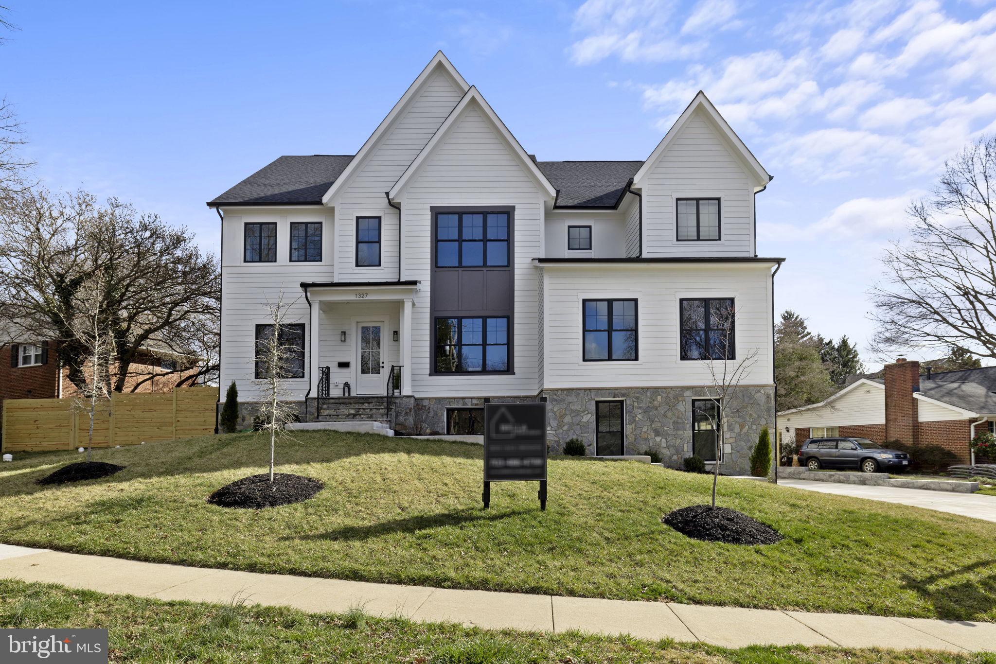 BELLISSIMA IN BROYHILL – Taking pride of place in this sweetly sloping corner of Broyhill McLean Estates, 1327 Mayflower Dr. is the perfect marriage of style, comfort, and space. With a full 7 bedrooms and 7.5 baths, this fully finished 7,136sqft newly constructed Craftsman-style home is truly awe-inspiring. But this masterfully crafted mansion of more than 7,000 square feet, executed by the renowned regional team at Bella Home Design, boasts far more than size. The moment you enter, past the facade of smart white siding and foundation-level stone, you will be immediately dazzled by the sophisticated and thoughtful touches that easily put this winner in a class of its own. Light wide-plank wood floors are seductively complemented by a color palette of black, white, and touch of cappuccino. The paneled walls, fire features, and sublime light fixtures fill this vast space with tasteful country-contemporary style. Natural wood accents add a signature stamp of truly thoughtful design, while the 10-foot ceilings ensure the mood remains uplifting and light. Past the formal living and dining rooms, the gorgeous kitchen competes with the central great room to be heart of this superior home. While the superlative JennAir appliance package is a practical nod to quality, it’s impossible to ignore its beauty, along with the cool, gray quartz countertops. The practical and playful dance along the staircase, as an automated light show guides your way. As you ascend, however, you may be distracted by the breathtaking picture windows that rise with you. On this upper level, the primary suite is a world unto itself, with sitting areas, vast walk-in closet, and a truly transportive spa bath in marble, black, and natural light. Amid the multiple large bedrooms and designer en suite baths, take a moment to appreciate the incredible possibilities of the lowest level, where wet bar and gas fireplace add intimacy to expansiveness. Returning to the practical, an anteroom ready for raincoats and snow boots connects to a pristine 3-car garage. As long as we’re headed outside, let’s explore this fully fenced quarter-acre-plus yard, complete with attached screened porch boasting no-maintenance engineered flooring. If, however, you must tear yourself away from this wonderful residential world all its own, shopping and dining are easily nearby, while you’re barely a mile to I-495 or the Dulles Access Road. From top to bottom, inside and out, 1327 Mayflower Dr. will have you living la dolce vita, NoVa-style.
