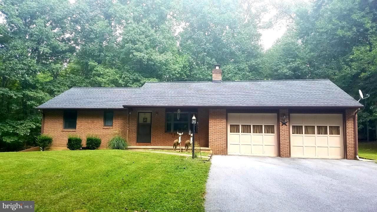 Lovingly maintained brick rancher surrounded by over 2 and a half acres of tree lined land just waiting for your finishing touches.  Bay window brings in lots of natural light, hardwood floors underneath the existing carpeting.  New roof in 2016. Over-sized attached 2 car garage with workshop plus additional 2 car garage, storage sheds and wood shed. Private and spacious setting with tons of potential. Cozy, quiet and move in ready!