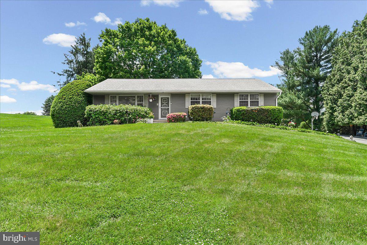 Meticulously maintained raised ranch situated on a flat, private 1.5-acre lot in the desirable Avon Grove School District. This move-in ready home offers 4 bedrooms and 2.5 bathrooms with a functional, comfortable layout designed for everyday living. The main level features LVP flooring and carpeting throughout. The light-filled living room creates a warm and inviting atmosphere, while the kitchen showcases quartz countertops, custom cherry cabinetry, and overlooks the patio and expansive backyard. The adjoining dining area provides the perfect setting for gatherings and entertaining. The primary ensuite bedroom offers ample closet space and includes a convenient laundry chute. Three additional bedrooms and a full hall bath (also with  laundry chute) complete the main level. The lower level features a half bath, laundry area, walk-out access, garage entry, and a large unfinished space ideal for storage, hobbies, or future finishing possibilities. Recent updates include: roof (2021), whole-house interior painting (2023), new carpeting (2023), and garage door (2026) and more! Please see documents for a complete list of updates.