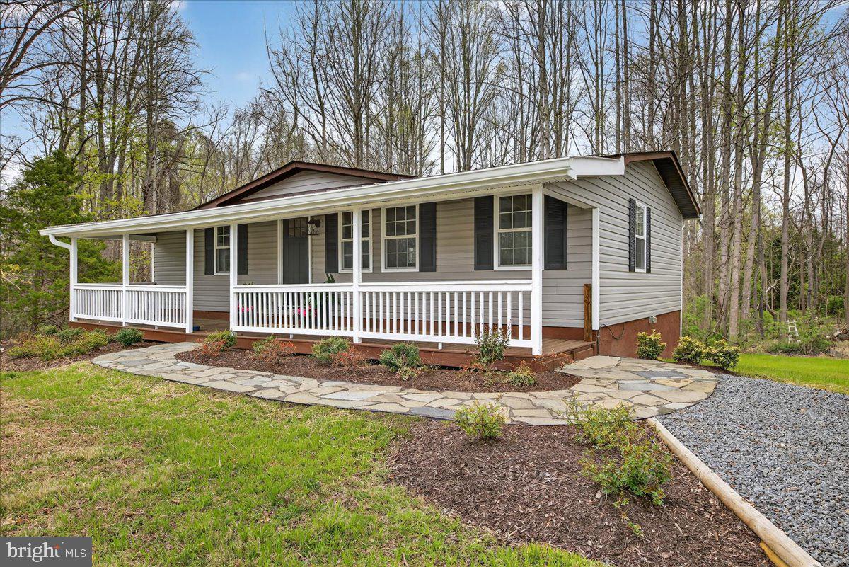 Completely remodeled and thoughtfully reimagined, this two-bedroom, two-bath home offers a warm, inviting interior paired with a layout designed for everyday comfort and effortless entertaining. The main living space features rich flooring, exposed beam ceilings, and a beautifully updated fireplace that creates a natural focal point and adds character throughout.

The kitchen has been upgraded with modern cabinetry, sleek countertops, and a clean, functional design that flows seamlessly into the dining area. Large windows and sliding glass doors bring in natural light and connect the interior to the spacious rear deck, creating an easy indoor-outdoor living experience.

Both bedrooms offer a comfortable, well-appointed feel, designed to provide a sense of retreat and simplicity.

A covered front porch with wood detailing sets the tone from the moment you arrive, offering a welcoming space to relax and unwind. The large rear deck overlooks a natural, wooded setting, providing privacy and a peaceful backdrop.

The unfinished basement presents a valuable opportunity for future expansion, allowing the next owner to create additional living space, a recreation area, or storage tailored to their needs.

The property also includes an assigned deep-water boat slip, making lake access convenient and enjoyable. Located just minutes from Lake Anna’s popular waterfront dining, shopping, and local attractions, and equipped with high-speed internet, this home offers a balanced combination of comfort, character, and potential.