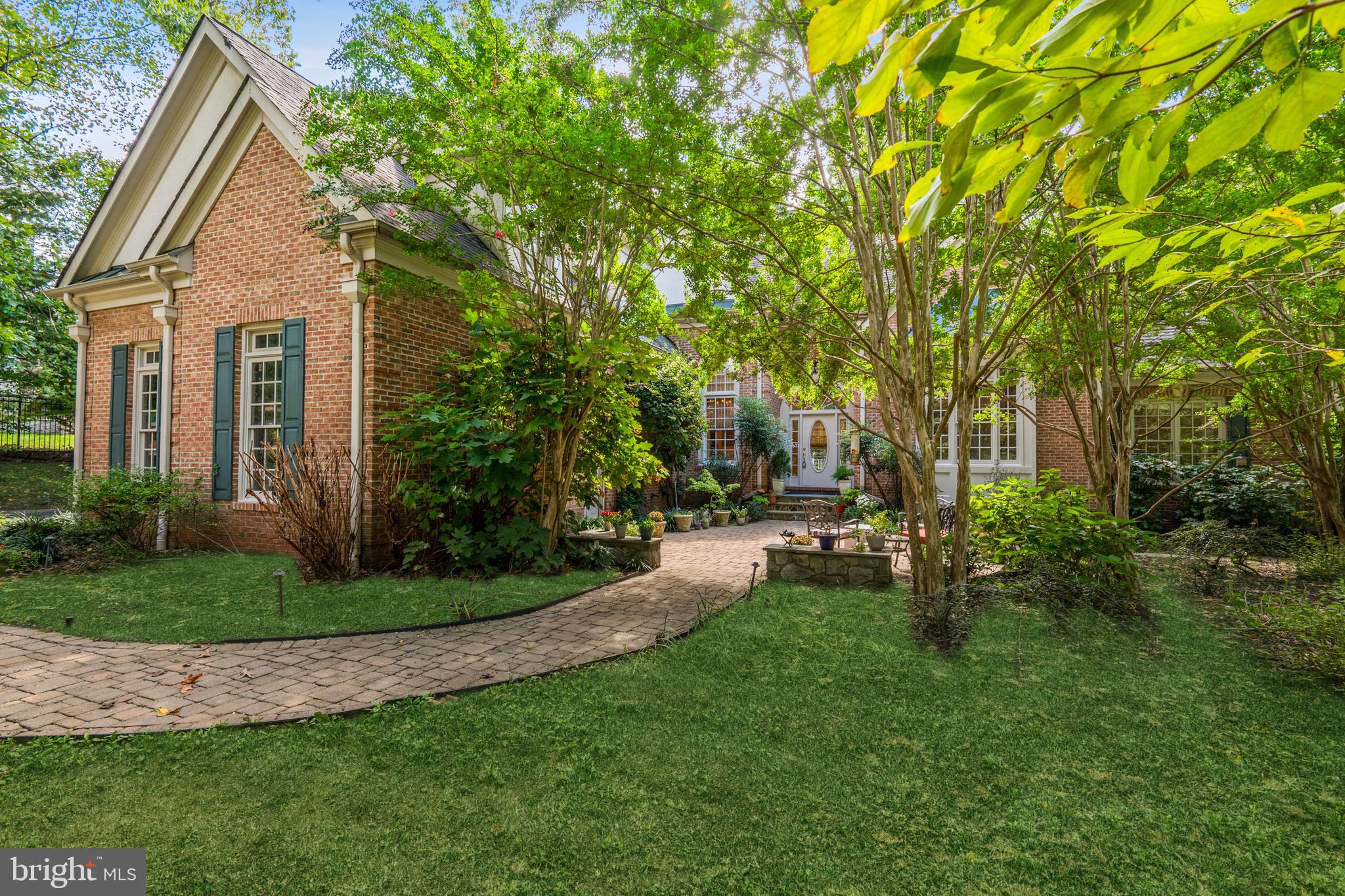 Price Reduced - great value! Offers due 11/15 before 6:00 PM. Lovely custom home on a large landscaped lot, offering a quiet, leafy retreat - and rarely-found true main level primary bedroom suite - in a prime McLean neighborhood of luxury homes, secluded yet close to major roads, shopping and award-winning schools.  Owner has just completed improvements on this 6,000+ finished-square-foot home.  A gated drive leads to the impressive brick residence with elegant arched entryway and large Palladian windows. Spacious and light-filled, the home's open floor plan provides an easy flow through rooms with lofty two-story ceilings and large, beautiful windows. Lovely hardwood floors, elegant moldings, built-ins and custom lighting add elements of luxury to every room, especially the open Living and Dining Rooms, Family Room and Library at its heart. The spacious, updated center isle Gourmet Kitchen has a Breakfast Area and  adjoins the large, comfortable Family Room with access to the outdoor Deck overlooking the grounds. The main level Primary Bedroom Suite offers a spacious retreat with sitting area, built-ins, wonderful walk-in closets and large ensuite Bath. A second Bedroom on the main level enjoys its own ensuite Bath. Upstairs, two additional Bedrooms each have ensuite Baths, and there is generous bonus space for study or play. The entire Lower Level of the house is a large and beautiful, fully-finished above-ground, walkout space providing a full floor of entertaining and recreational space. The Great Room with fireplace  is equipped with a full bar; a Media Room provides for more fun, and a caterer's Kitchen supports the entertainment. A Gym, full bath and Study/5th Bedroom all provide a walk out to the gardens. The fully fenced property includes a 3-car garage, central vacuum, generator, recently-connected public sewer, 3 zones HVAC, many improvements and is offered in excellent condition. The unique and exceptionally beautiful home is located in the Langley school pyramid and is one mile from the Beltway yet very quiet. Don't miss this fine property!