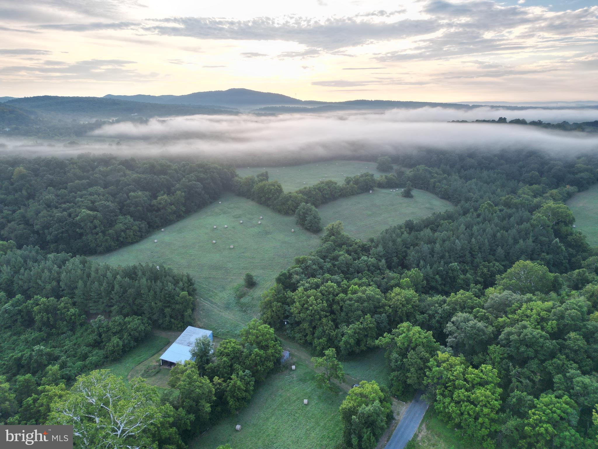 Welcome to a truly extraordinary opportunity to own a sprawling 111-acre sanctuary nestled along the  Upper Potomac River. This unique farm, accessed via a paved road and secured by a private gated entrance, offers an unmatched blend of natural beauty, recreational potential, and agricultural versatility — all within convenient reach of major regional hubs.

A Private Retreat with Unparalleled Waterfront Access

From the moment you enter the property  you are embraced by a landscape that feels both wild and welcoming. Spanning 111 acres of pristine countryside, this land boasts over 2,000 feet of breathtaking frontage along the Upper Potomac River, creating an idyllic setting for river lovers, anglers, and outdoor enthusiasts alike.

A rare  feature of the farm is its exclusive direct river access through a hand-built stone tunnel — an extraordinary passage that runs beneath the historic train tracks. This private portal not only offers unparalleled ease for fishing, or simply savoring the peaceful waterside atmosphere but also adds a unique historical charm to the property, setting it apart from any other riverfront acreage on the market.

Diverse and Productive Agricultural Land

The farm features 24 acres of tillable land, currently dedicated to hay production. This productive farmland offers excellent potential for various agricultural pursuits, from hay farming to crop cultivation or even planting food plots to grow and hold an already thriving deer herd. 

Adding to the charm, a large barn stands on the property, perfectly suited for hay storage or as a functional hub for farm operations. The barn’s spacious interior provide ample room for equipment, feed, and livestock, making it ideal for both hobby farmers and serious agricultural entrepreneurs.

Abundant Wildlife and Outdoor Recreation

Hunters and outdoor enthusiasts will fall in love by the large and diverse populations of animals that frequent this property. A sizable flock of wild turkeys regularly visits the fields and woodlands, creating dynamic wildlife watching and hunting opportunities. Moreover, ample numbers of deer inhabit the property year-round, providing excellent hunting opportunities. This farm sets up well for the individuals looking to manage a deer herd and attract those large bucks from just across the river.

Perched strategically within the landscape is a large elevated hunting blind offering panoramic views across three expansive fields.  To the west of the blind is where a previous food plot was carved out. Many turkeys and deer have been harvested from this location as it sits against a large block of timber and just up the banks from the river. The height of this tower blind gives opportunity to see roughly 270 yards across the field to give ample coverage of those cruising deer during the firearms season.

Waterways and Natural Features

In addition to the river frontage, the property is graced by over 1,000 feet of Big Run, a  stream that meanders through the landscape. This waterway adds a peaceful, soothing ambiance and supports a diverse range of wildlife. 

A well-maintained trail system winds throughout the farm, allowing easy and enjoyable traversal across the fields, forests, and along the waterways. These trails connect all the property’s key features and make it convenient to explore every corner, whether on foot, horseback, ATV, or mountain bike. The trail network enhances accessibility while preserving the land’s natural charm and beauty.

Protected Scenic Views and National Park Access

One of the most remarkable aspects of this estate is its adjacency to the Chesapeake and Ohio Canal National Historical Park. This protected national park guarantees that the stunning views across the river will remain. 

Don't miss the opportunity to own would could very well be the best farm in Morgan County on the banks of the Potomac River.