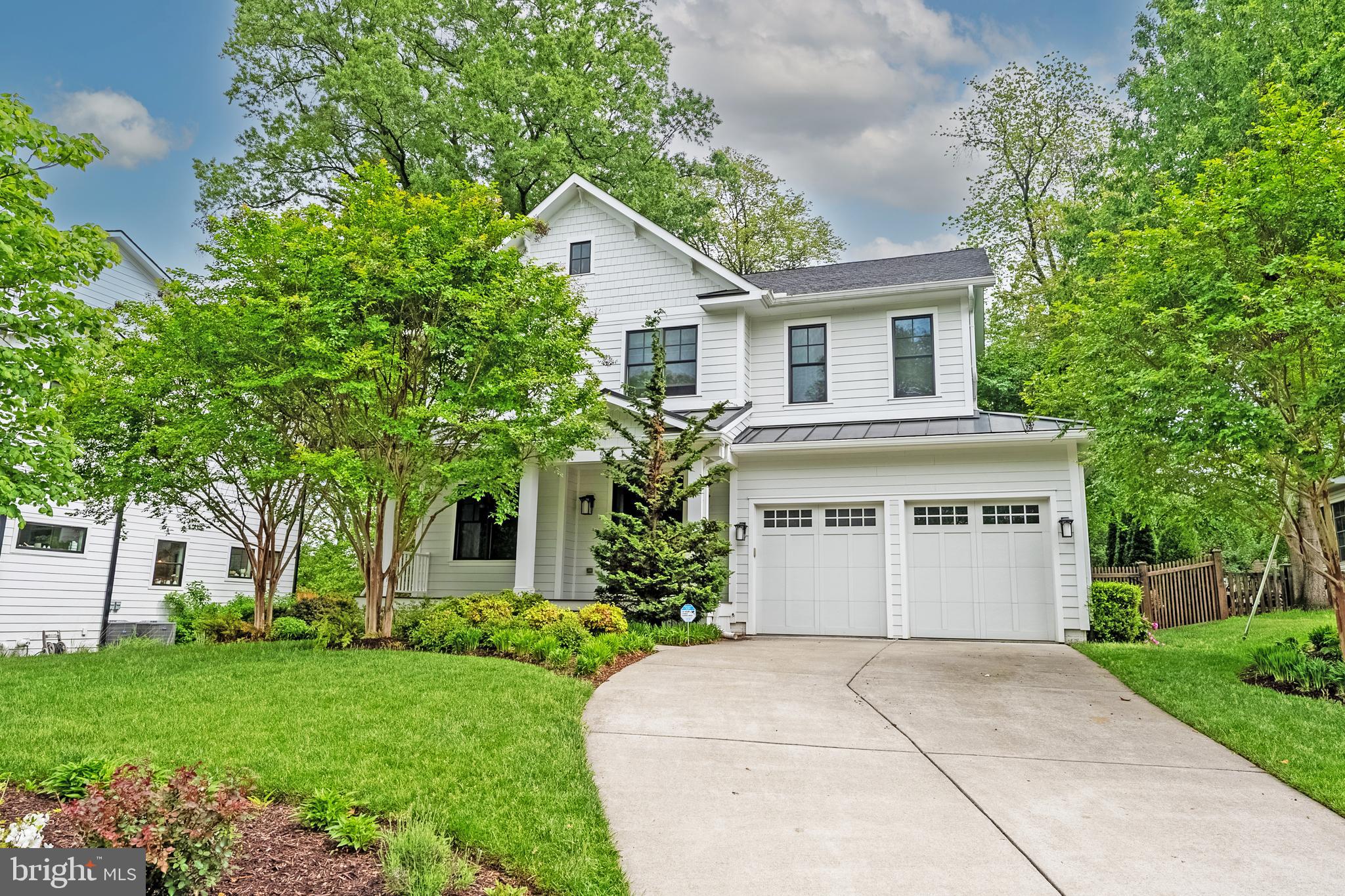 Nestled within the sought-after West Vienna Woods community, this exceptional craftsman residence offers an unparalleled blend of sophistication, comfort, and outdoor serenity. Thoughtfully designed with exquisite attention to detail, the home boasts an inviting outdoor oasis with a sparkling in-ground pool—a perfect retreat for relaxation and entertaining. A charming metal-seamed roof front porch with a natural wood ceiling and inviting sitting area welcomes guests with warmth and elegance, offering the perfect spot to greet neighbors and enjoy the community ambiance. Stepping inside, rich sand-in-place oak hardwood flooring, soaring 9-foot ceilings, and a dramatic open floor plan create a breathtaking first impression. A set of French doors with a transom window leads to a versatile front office or formal living room, featuring a tray ceiling for added architectural distinction. Wainscoting flows seamlessly from the foyer into the elegant formal powder room, setting a refined tone. The formal dining room is beautifully appointed with ¾-height wainscoting, a tray ceiling, and a chic drum-shade chandelier, creating an atmosphere of timeless sophistication. The heart of the home, a stunning great room, is anchored by a gas fireplace with a white marble-inspired surround, framed by an elegant coffered ceiling. Natural light floods the space through floor-to-ceiling French doors, which lead to the rear deck and resort-style pool, blurring the lines between indoor and outdoor living. Designed for the culinary enthusiast, the gourmet kitchen showcases shaker-style white cabinetry, an expansive gray center island, white marble countertops with delicate veining, a coordinating marble backsplash, and premium JennAir stainless steel appliances. The sunlit breakfast area is enhanced by a built-in bench and a well-appointed wet bar, complete with glass-paneled cabinetry, a prep sink, and a wine refrigerator. A mudroom with built-in cubbies and a coat closet ensures effortless organization. Ascending the beautifully detailed switchback staircase with white risers and wainscoting, the upper level continues with gleaming hardwood floors throughout. The Primary Suite is a private sanctuary, boasting a coffered ceiling, a modern ceiling fan, and a generously sized walk-in closet. The spa-inspired Primary Bath invites relaxation with dual oversized vanities, white marble countertops, pivot mirrors, a shiplap accent wall, and a separate water closet. A luxurious oversized shower features floor-to-ceiling white tile, a marble accent listello, multiple showerheads, a built-in bench, and a frameless glass door. For the ultimate indulgence, a voluminous soaking tub offers a tranquil retreat at the end of the day. Three additional bedrooms, including one with a private en-suite bath and walk-in closet, provide comfortable accommodations. A spacious hall bath with dual vanities completes the upper level. The remodeled lower level is an entertainer’s dream, featuring heated tile flooring, a stylish recreation room with a shiplap accent wall, and a walk-up stairwell leading to the backyard. A fully equipped bar area impresses with white oak-style cabinetry, quartz countertops, a stainless-steel beverage fridge, a kegerator, and bar-top seating—perfect for hosting guests. A private office/den, an exercise room with rubber flooring and a mirrored wall, a fifth bedroom, a full bath, and a mechanical room complete this level. Outside, the thoughtfully designed Trex deck features a graceful curved edge and steps that flow seamlessly into the paver patio, mirroring the organic lines of the custom-designed pool and stone retaining walls. Located in the heart of Vienna, just two blocks from the vibrant shops and restaurants of Maple Avenue, this home enjoys the charm of a tight-knit community, with easy access to multiple parks, and the local farmers market. **Vienna Elem., Thoreau Middle, and Madison High School
