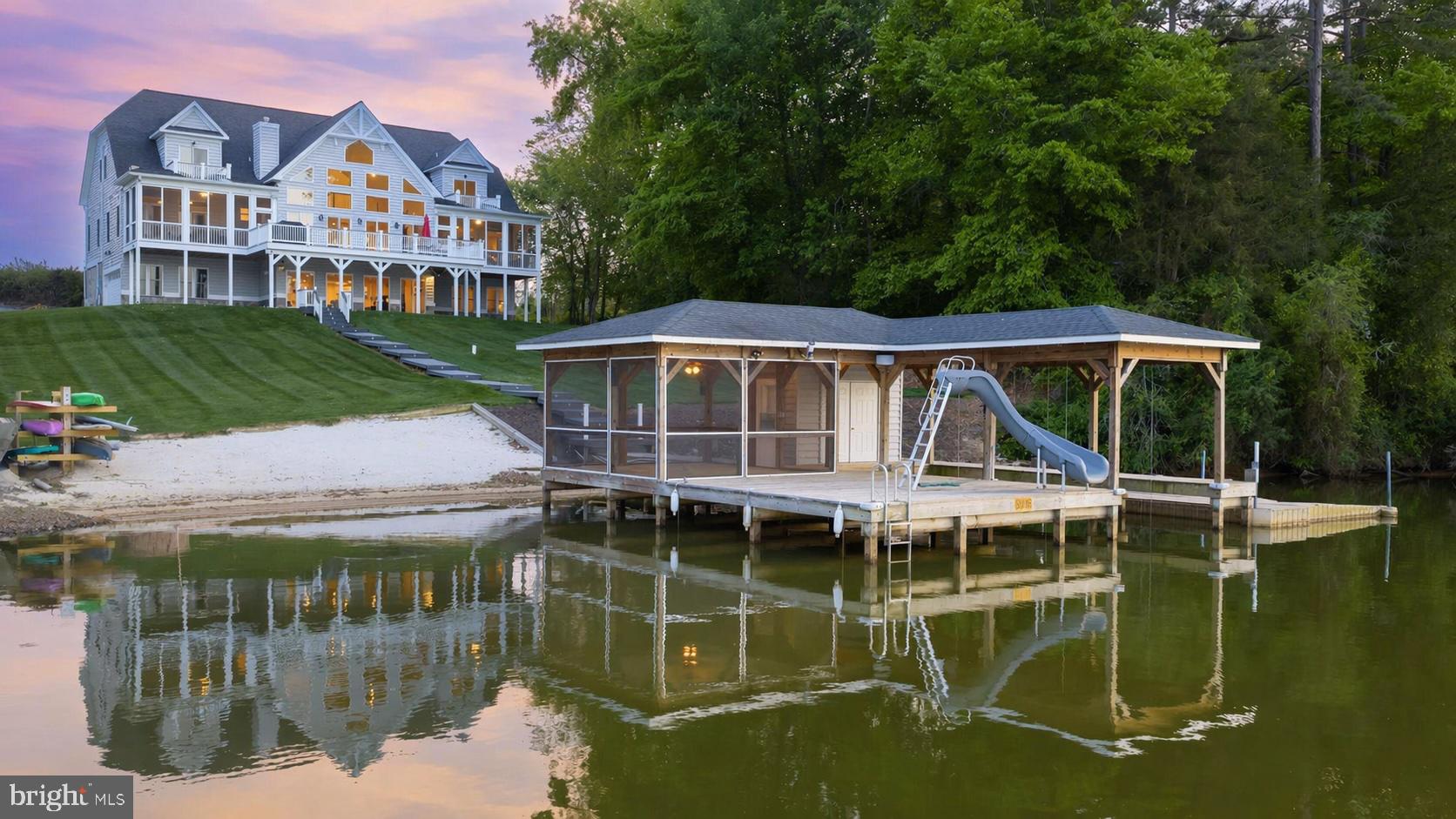 Welcome to resort-style living on the public side of Lake Anna, where long sunny days, sparkling water, and unforgettable sunsets become your everyday backdrop. Built in 2019 and set on just over an acre in the desirable Summerview Point community (with no HOA), this stunning Craftsman-style waterfront home offers over 7,000 square feet of beautifully finished space designed for both relaxation and entertaining—and is being sold fully furnished with an acceptable offer, making it truly turn-key! With 150 feet of pristine shoreline, the setting delivers the ultimate lakefront experience from every angle. From the moment you walk in, you’re greeted by soaring ceilings, a wall of glass framing the lake, and water views from nearly every room. The open floor plan allows the kitchen, family room, and dining areas to flow effortlessly together, creating the perfect setting for gatherings. The gourmet kitchen features a massive center island, granite countertops, and stainless steel appliances—ideal for hosting after a day on the water. The main-level primary suite features a beautifully appointed bath, walk-in closets, and private access to a screened porch overlooking the lake. Upstairs, two spacious bedroom suites each enjoy their own private balconies and baths, creating a peaceful escape for guests. The walkout lower level is built for entertaining, complete with a full kitchen, expansive recreation and dining areas, two additional bedrooms, a full bath, and plenty of space to unwind. Step outside and the lifestyle truly comes alive—composite decking, multiple screened porches, balconies, and patios all designed to take in the breathtaking views and fresh lake air. Down at the water’s edge, you’ll find everything you could want for the ultimate lake experience: a deep water covered boathouse with electric lift, sun deck with slide, triple jet ski pad, storage room, and a huge sandy beach perfect for lounging or playing by the water. Gather around the lakeside fire pit as the sun sets, or spend your days cruising, swimming, and soaking it all in. 2-car garage, paved driveway and lake-fed irrigation. Located less than 2 hours from Washington, D.C., this home is perfect for even a quick weekend trip. Enjoy close proximity to local dining and favorites like Tim’s at Lake Anna, Moo-Thru for ice cream and mini golf, The Cove restaurant, and nearby marinas. With high-speed FiberLync internet and short-term rental potential offering strong income opportunities, this property delivers not just a home—but a lifestyle of lakefront luxury, fun, and lasting memories. Rental Projection in MLS Documents.