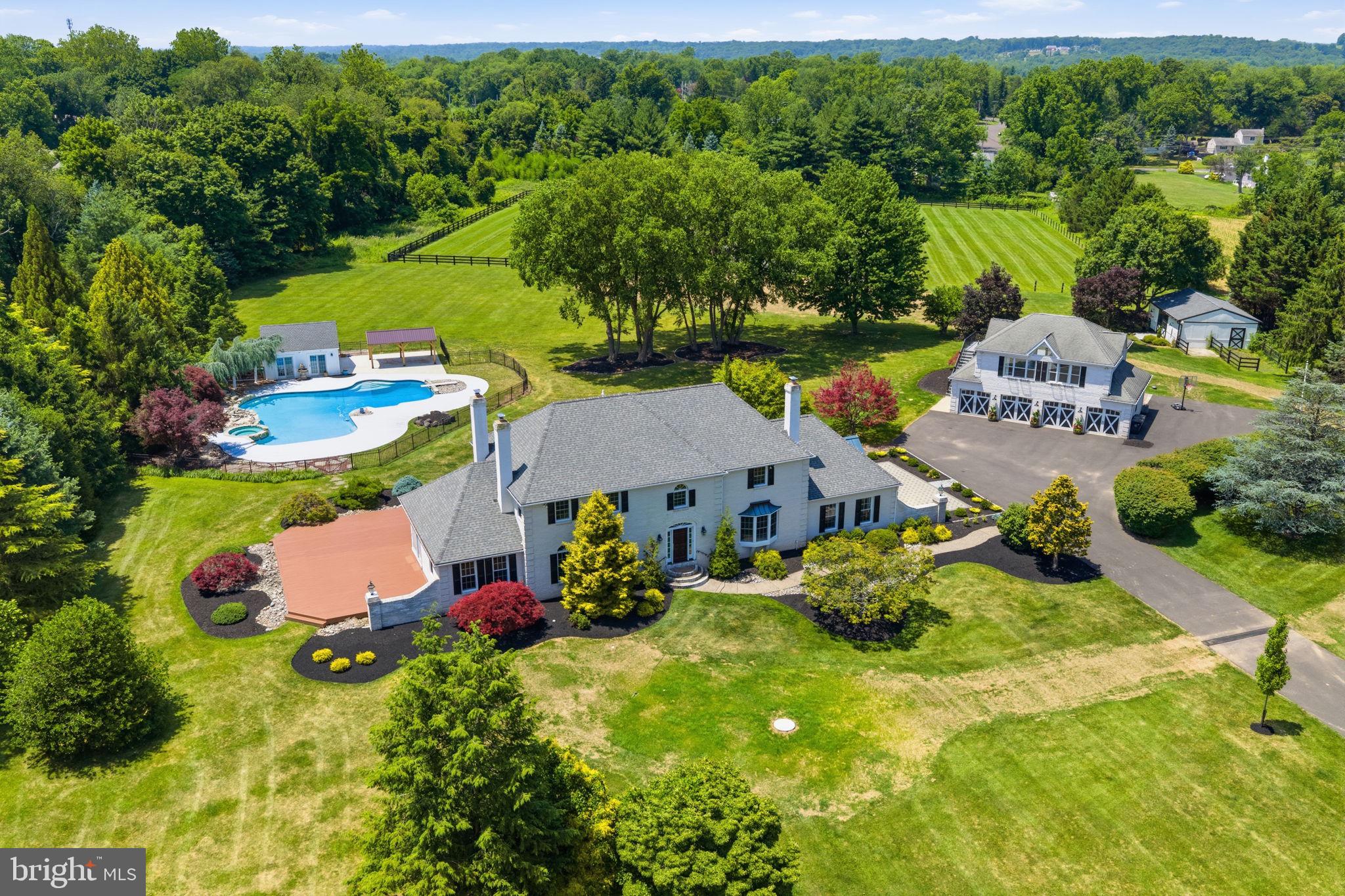 Welcome to an extraordinary equestrian estate tucked away within the exclusive private enclave of Two Ponds. Set on more than 10 beautifully landscaped acres, this remarkable property offers the perfect balance of luxury living, privacy, and exceptional equestrian amenities. A long drive winds through manicured grounds and fenced paddocks before arriving at the impressive 4,500-square-foot residence. Inside, a welcoming foyer with elegant travertine flooring and a sweeping staircase introduces the home's timeless design. Five fireplaces throughout the home create a warm and inviting atmosphere, while spacious living and dining areas provide ideal settings for both everyday living and entertaining. The recently updated gourmet kitchen is designed to impress, featuring granite countertops, custom tile backsplash, premium stainless steel appliances, an oversized built-in JennAir refrigerator/freezer, under-counter speed oven, expansive walk-in pantry, and a bright morning room perfect for coffee or casual dining. The kitchen flows seamlessly into a generous family room filled with natural light and custom built-in cabinetry. The main level offers exceptional flexibility with a private bedroom or den opening into a sunroom, making it ideal for guests or multi-generational living. A dedicated home office overlooks the picturesque front grounds, providing an inspiring workspace. Upstairs, the luxurious primary suite serves as a peaceful retreat, complete with its own fireplace, private balcony overlooking the property, and a beautifully appointed spa-inspired bath. Two additional bedrooms and an updated full bath complete the second floor. The finished walk-out lower level expands the home's entertaining space with a recreation room, full bath, wet bar, and plenty of room for movie nights, game days, or hosting family and friends.
Outdoor living is equally impressive. A custom mudroom provides easy access to the expansive paver patio, while the resort-style backyard showcases a heated freeform pool with spa, a well-appointed pool house with powder room, and a convenient service kitchen, creating an exceptional setting for summer entertaining. Car enthusiasts, hobbyists, or those needing additional workspace will appreciate the detached heated four-bay garage with its own half bath. Above, a second-floor in-law suite/guest house offers comfortable accommodations for extended family or overnight guests. Designed with horse enthusiasts in mind, the property's equestrian facilities include a three-stall barn, each stall featuring its own run-out paddock, along with a tack and feed room complete with custom wood finishes and built-in storage. A riding arena with excellent drainage, plus two spacious turnout pastures, provides outstanding facilities for riding, training, and daily care. Despite its peaceful, country-like setting, the estate is conveniently located near shopping, dining, and major commuting routes, offering the best of both privacy and accessibility. Whether you're an avid equestrian or simply searching for a truly exceptional luxury property, this one-of-a-kind estate delivers an unmatched lifestyle where refined living, breathtaking surroundings, and thoughtfully designed amenities come together in perfect harmony.
