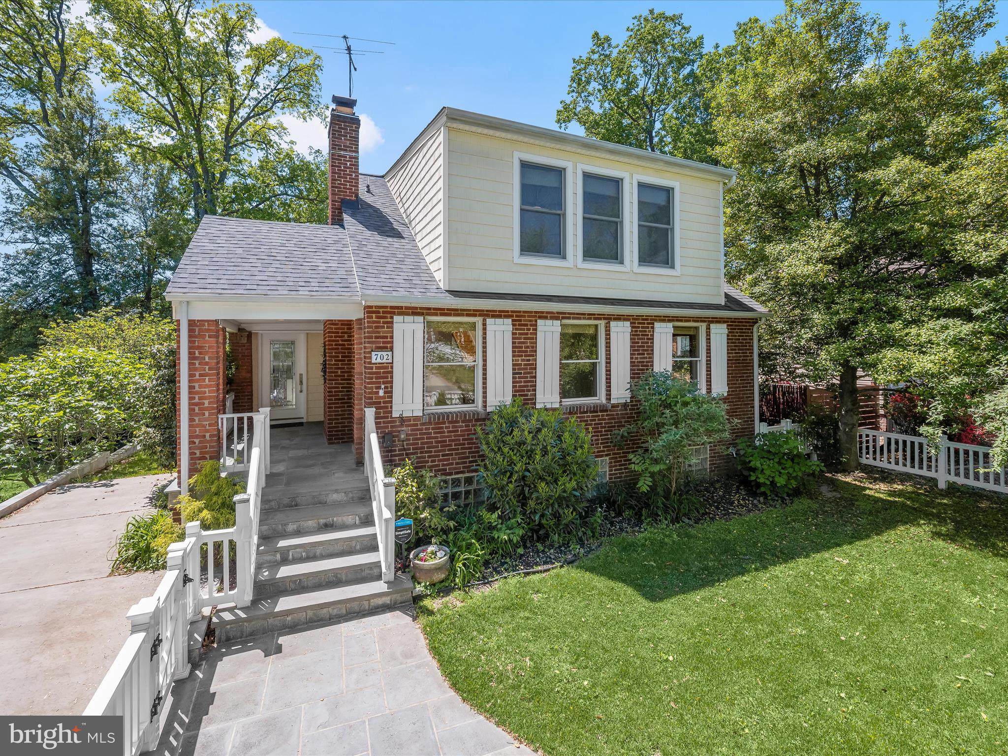 Welcome to this beautifully updated three-level home that blends modern comfort with timeless character, located just over a mile from the heart of Downtown Silver Spring. A charming white picket fence and manicured front yard set the stage, with a slate stone walkway guiding you to the covered front porch, a perfect spot for morning coffee or evening conversation. From here, step directly into the living room or kitchen, each entrance offering its own warm welcome. Inside, the expansive living room showcases gleaming hardwood floors and a brick-accented wood-burning fireplace, creating a cozy yet spacious atmosphere for gathering. Flowing seamlessly from the living area is the open-concept kitchen and dining room, where a vaulted ceiling and two skylights flood the space with natural light. The kitchen has been thoughtfully renovated with sparkling counters, stainless steel appliances, and cabinetry outfitted with multiple roll-out storage options. A center island with breakfast bar invites casual meals and conversation, while the adjoining dining area opens to a spacious deck through sliding glass doors, perfect for outdoor entertaining. The main level also offers a versatile bedroom and full bath, ideal for guests, a home office, or multigenerational living. Upstairs, two skylights brighten the hallway, leading to two generously sized bedrooms, each with a vaulted ceiling and en-suite bath. The primary suite impresses with three closets, plentiful windows, and a luxurious bath featuring a jetted soaking tub and beautifully tiled shower surround. Downstairs, the fully finished lower level provides even more living space, including a recreation room with luxury vinyl plank flooring, a wet bar with beverage refrigerator, a stylish half bath, and a fourth bedroom. A barn door reveals the laundry room, complete with utility sink and storage, and there’s a dedicated room for a workshop or additional storage needs. Step outside from the lower level to a private backyard framed by mature trees, with a storage shed and space to relax or play. Thoughtful updates add lasting value: the roof is just three years old, and both the driveway and retaining wall were recently redone. The home is outfitted with quality Andersen windows that enhance both form and function. Additional upgrades include a tankless water heater replaced in 2021 and a dual-zoned HVAC system replaced in 2024. Parking is easy with both a driveway and street options available. Life on Gist Avenue offers easy access to the dynamic energy of Downtown Silver Spring. From shops and restaurants to cultural landmarks like the AFI Silver Theatre and The Fillmore, there’s always something to explore. Seasonal events at Veterans Plaza, the nearby Metro station, and an abundance of parks and trails round out this ideal location, placing everything you need right at your doorstep.