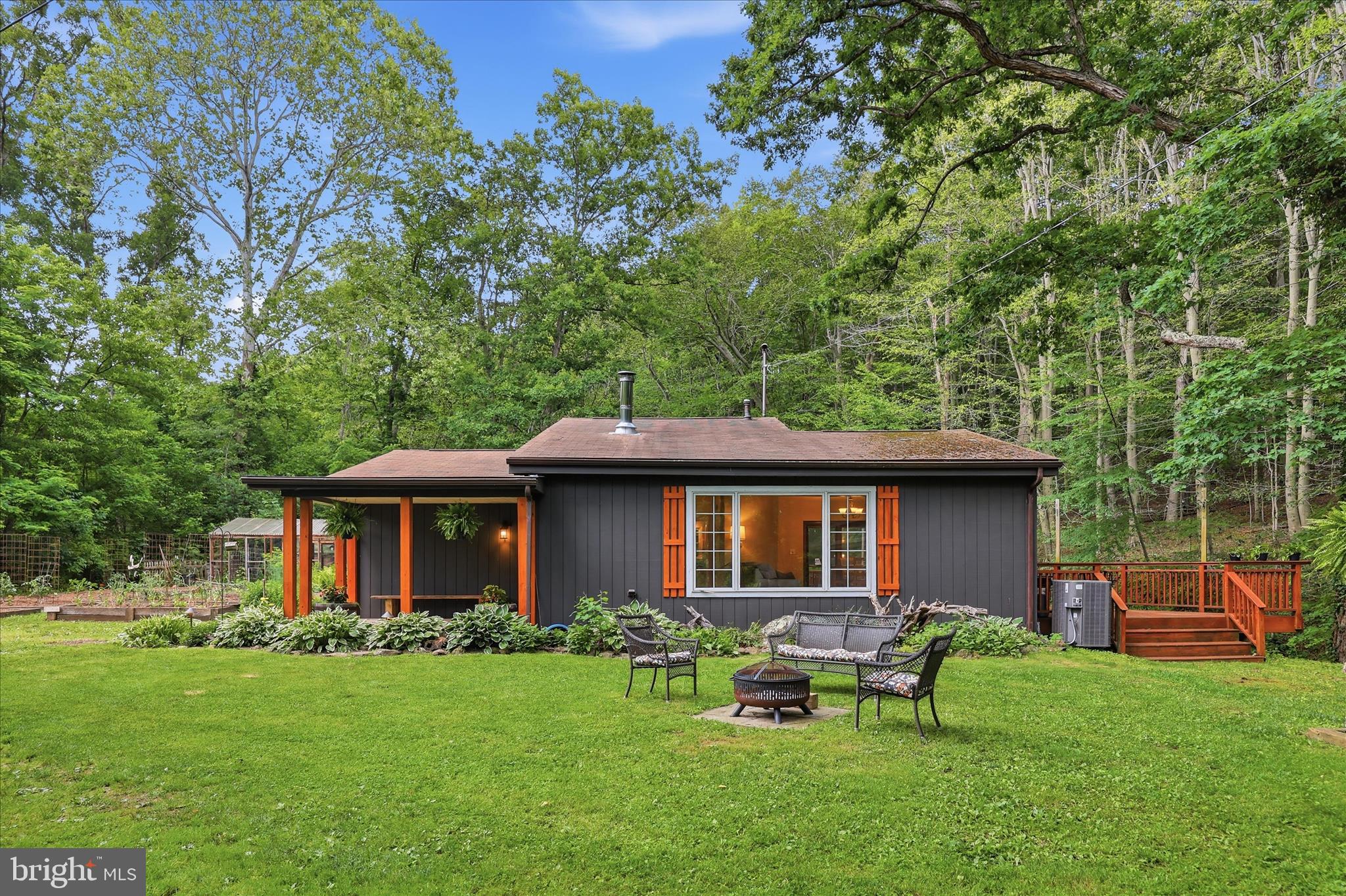 Creekside living meets small-scale homesteading on this picturesque farmette nestled along the banks of Middle Creek. Situated on two parcels totaling 2.4 acres and surrounded by mature trees and open green space, this special property offers the ease of single-floor living with the perfect blend of comfort, charm, and connection to nature.
Inside, vaulted ceilings, a cozy wood stove, and large windows create a warm and welcoming living area. The spacious kitchen opens to a wraparound porch overlooking the creek and the protected woodland beyond, offering a peaceful setting for relaxing or gathering with friends and family. A generously sized laundry room provides abundant pantry and storage options. The second bedroom includes an adjoining flex room ideal for a home office, walk-in closet, playroom, or nursery.
Outside, enjoy raised garden beds, a chicken coop, and plenty of room to play, garden, and explore. A bonus studio and a large shed, heated by its own wood stove, provide flexible spaces for a studio, workshop, working from home, or hosting family and friends.