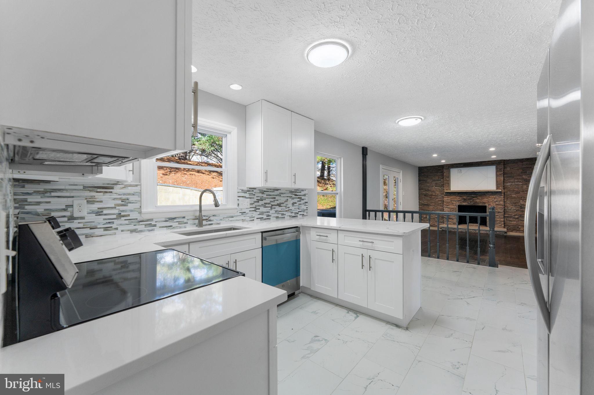 Stunning and extensively updated 4-bedroom, 3.5-bath home offering over 2,700 finished square feet in the highly sought-after Tanglewood neighborhood. Combining the feel of new construction with the space and charm of an established community, this move-in-ready home is sure to impress. From the moment you arrive, you'll appreciate the elegant custom stonework that enhances the front exterior and continues into the backyard, where a spectacular oversized stone patio creates the perfect setting for entertaining, outdoor dining, or simply relaxing in your private backyard retreat. The beautifully renovated gourmet kitchen features new cabinetry, quartz countertops, designer backsplash, stainless steel appliances, and elegant tile flooring. The main level also offers a spacious family room with a stylish tiled fireplace, formal living and dining rooms, and refinished hardwood flooring throughout. New sliding door from the family room lead directly to the fully fenced backyard. Upstairs you'll find four generously sized bedrooms, including a luxurious owner's suite with a large walk-in closet and beautifully updated spa-inspired bath. The finished lower level offers exceptional flexibility with a potential fifth bedroom, guest suite, or home office, an updated full bath, a large recreation area, and walk-up access to the backyard.  Additional updates include a new AC (2025), new water heater (2025), new backyard fencing, replaced garage doors, and newer carpeting. The oversized two-car garage provides ample storage space. Ideally located near Routes 29 and 200 with convenient access to shopping, dining, parks, and major commuter routes, this home offers an exceptional combination of style, comfort, and convenience in one of the area's most desirable neighborhoods.