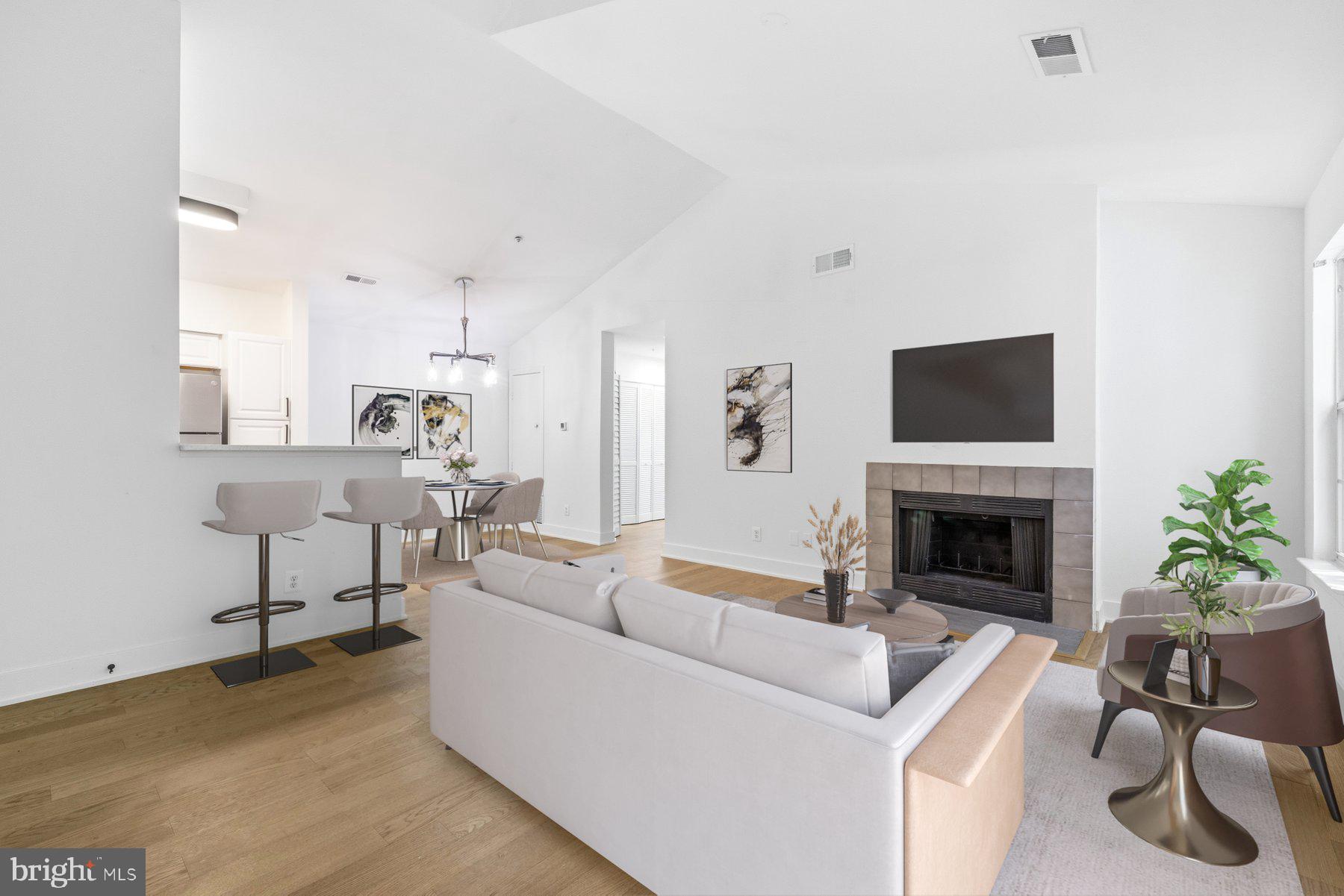 Welcome to this beautifully renovated top-floor condominium where contemporary design meets everyday convenience. COMPLETELY RENOVATED (2026) from top to bottom, this exceptional 1-bedroom, 1-bath residence offers an open, light-filled floor plan highlighted by soaring vaulted ceilings, premium engineered wood flooring, newly installed lighting, and a cozy wood-burning fireplace. Sliding glass doors open to a private balcony overlooking peaceful wooded views, creating the perfect retreat to relax and unwind.

At the heart of the home is a stunning, brand-new gourmet kitchen featuring elegant Quartz countertops, new cabinetry with pantry storage, stainless steel appliances, ceramic tile flooring, and a stylish glass tile backsplash. The spacious bedroom offers dual closets and private access to the fully renovated bathroom, complete with a beautifully tiled tub surround, illuminated mirror, new vanity, updated fixtures, and modern finishes throughout. New full sized washer and dryer, reserved covered parking, and an exterior storage closet add to the home's convenience and functionality.

Residents enjoy an outstanding collection of community amenities including a swimming pool, tennis courts, fitness center, tot lots, walking trails, and abundant green space. Ideally situated just moments from shopping, restaurants, parks, and major commuter routes including I-270, Route 355, I-495, and the ICC, this home also offers easy access to BWI, Reagan National, and Dulles airports. Whether you're searching for your first home, downsizing, or looking for a turnkey investment, this move-in-ready residence delivers the perfect combination of style, comfort, and location......Welcome Home!