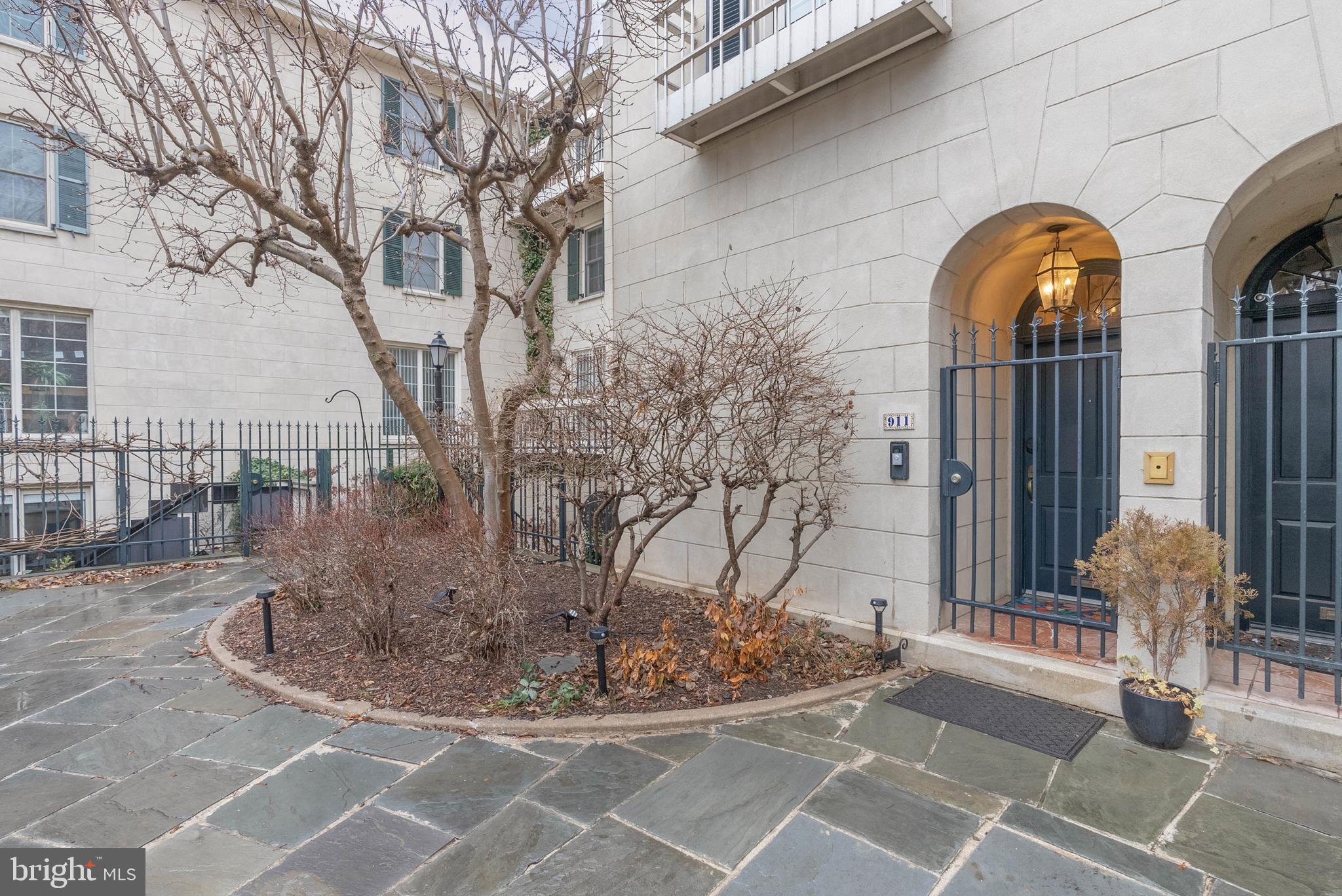 Bright, airy, and overflowing with architectural details, 911 Bonaparte Ct is a luxurious townhome nestled in a hidden enclave of private residences in the heart of Washington Square West. This expertly renovated property offers 3 bedrooms, 2.5 bathrooms, a deeded parking spot right out front, multiple outdoor spaces, and placement within the top-rated McCall School catchment. You're welcomed by an idyllic courtyard, with mature trees and manicured shrubbery that bloom during the warmer months. A gated threshold leads inside, where a mezzanine-style entry hall with hardwood floors and a coat closet creates a grand first impression, showcasing views of the lower level and the commanding center staircase. Natural light pours into this open layout from towering southwest-facing windows. Stepping down, you'll find a sunlit dining room benefiting from soaring 2-story ceilings. The relaxed family room is open to a sleek kitchen fitted with two-tone cabinetry, brass fixtures, black counters, a subway tile backsplash, and high-end appliances, including a Miele Induction cooktop and paneled refrigerator. Sliding doors lead to a paver patio, which also has access from the courtyard—perfect for entertaining. On the main level, built-in bookcases and a bathroom with a storage room sit off the staircase. The living room has a fireplace, a balcony, and an office alcove that can be hidden by drapes. The home's second level has two large bedrooms and a gleaming full bathroom adorned with herringbone tile, wall-mounted fixtures, a pair of intricate sink vessels, and heated floors. It also has the laundry and a pocket door that allows the soaking tub, shower, and toilet to be used privately from the vanity. Topping off the home is a hotel-like primary suite. It boasts a spacious bedroom with a fireplace, a dressing room with bespoke closets, a reading nook, a balcony, and another luxurious bathroom with heated floors, a double vanity, and a glass-enclosed shower. Utilities include central A/C, electric forced-air heat, and electric hot water, making the home gas-free. In addition to everything inside, this fantastic location earns a Walk Score of 97! It has a friendly, residential feel yet is only steps from Center City. Dining for all palates, shopping for all tastes, popular markets, and sprawling parks are within a few blocks. Neighboring Rittenhouse Square has lots to explore, plus there's easy access to Jefferson Hospital, Pennsylvania Hospital, and public transit. Schedule your tour today!