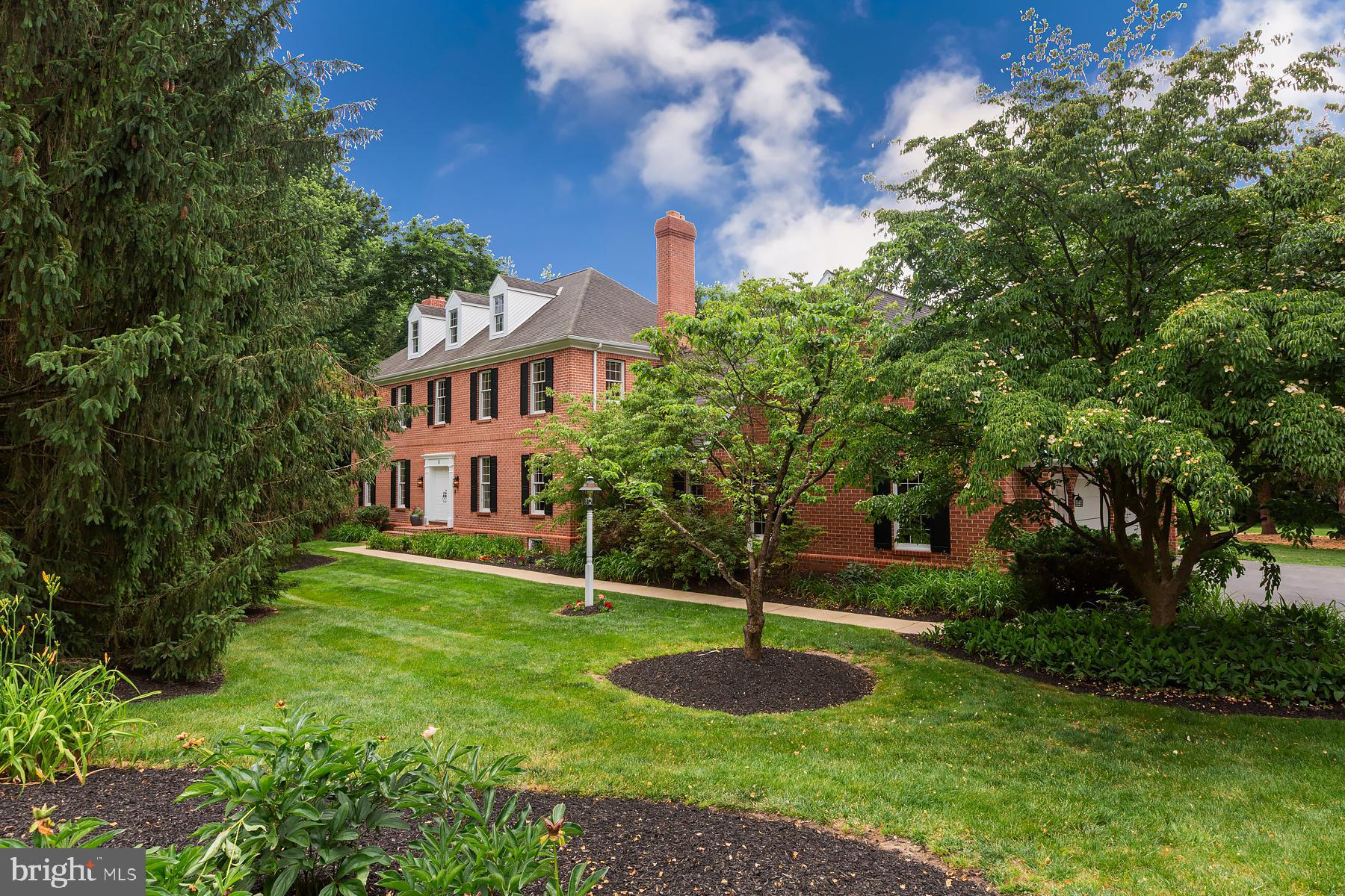 Tucked away on a quiet cul-de-sac in Lampeter-Strasburg School District, this stately Georgian style brick home sits on a beautifully landscaped one-acre lot surrounded by mature trees. A dramatic two-story foyer with classic checkerboard stone flooring and a sweeping staircase sets the tone for the timeless elegance found throughout the home. Offering 4 bedrooms, 3 full bathrooms, and a 3-car garage, the home features hardwood flooring throughout, 9-foot ceilings, wood built-ins and generously sized windows that showcase the lush green yard.  The family room is anchored by a brick wood-burning fireplace and custom built-in shelving, while a second wood-burning fireplace adds warmth and character to the formal living room off the foyer.  The first-floor office/bedroom showcases floor-to-ceiling built-ins. The kitchen offers solid wood cabinetry, a center island, breakfast area, and built-in hutch.  
Upstairs, the owner’s suite includes a private bath, dressing room, and additional closet space. Custom built-ins on the second-floor landing provide both functionality and architectural charm.
An easily accessible walk-in attic provides exceptional storage and future expansion potential above the family room and garage. Unfinished basement with all new windows is another area that could be expanded into.  Entire home freshly painted by Two Dudes Painters. Two-zone HVAC, two hot water heaters, mature landscaping, and an exceptional location convenient to the Lampeter-Strasburg School Campus, Lancaster City, shopping, dining, and major commuter routes.
This amazing property is a rare opportunity!
