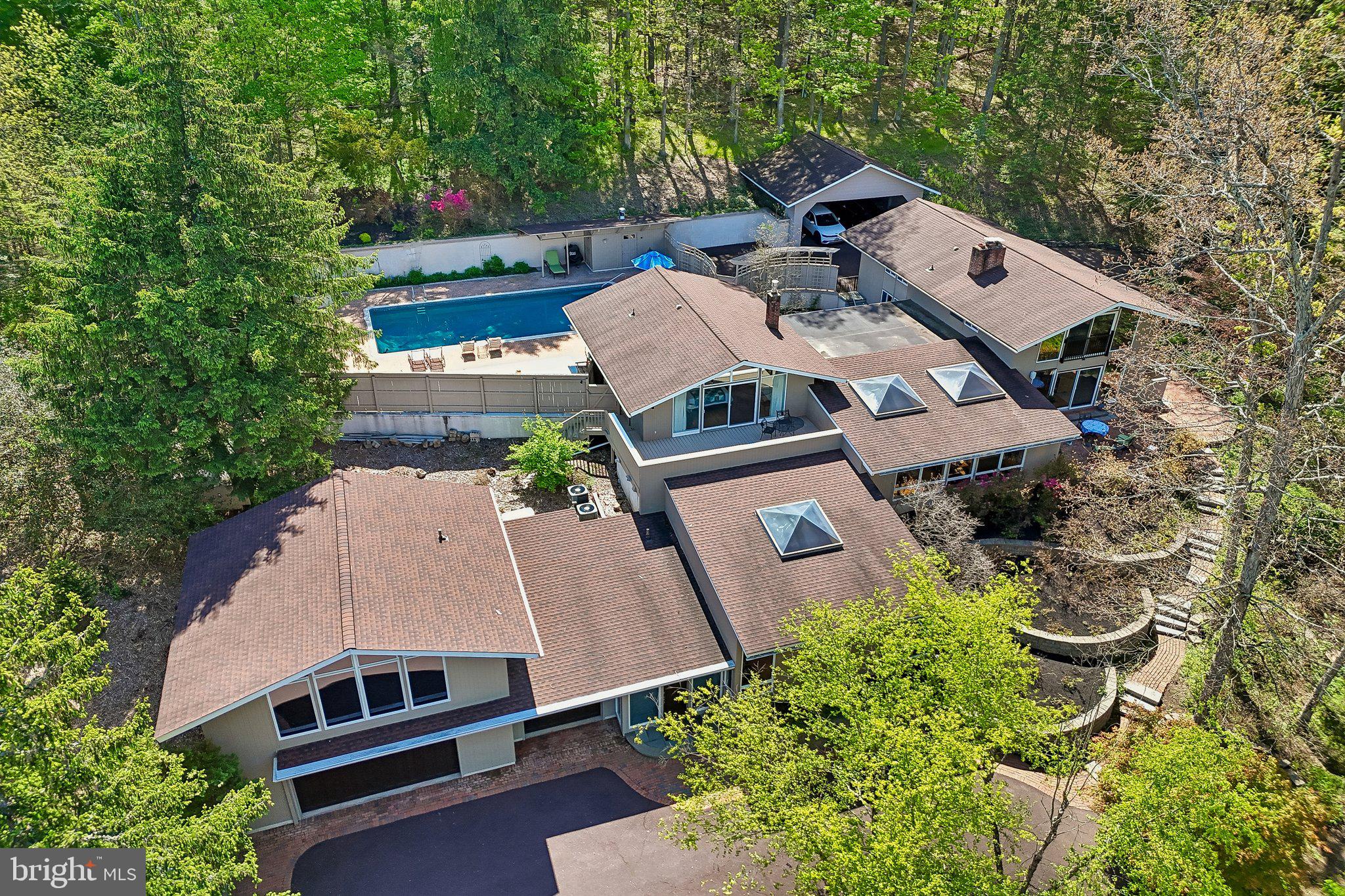 Experience the pinnacle of architectural significance and secluded luxury in this breathtaking executive estate. Originally envisioned as a Mid-Century Modern sanctuary, this home has been transformed into a sprawling work of art through a dramatic, COTY Award-winning addition by architect Michael Raphael, AIA. Every room was built to follow the natural curve of the land, creating incredible views and a layout that feels both grand and deeply personal. Inside, the house has been completely reimagined with a designer chef’s kitchen, featuring a spacious pantry, prep sink, double ovens, warming tray, six-burner cooktop, Sub-Zero refrigerator, hands-free trash containers, and endless counter space, along with high-end mechanical systems, ensuring that its classic character is matched by modern comfort. From the soaring ceilings to the sun-drenched art gallery, the home is wrapped in massive windows and skylights that bring the beauty of the outdoors into every corner.

This, is a property built for the host who loves to celebrate life. The living room, formal dining room, and central courtyard flow together to create one massive, open-air party space that opens directly to the shimmering pool. It is a place where music, laughter, and connections feel right at home, all while tucked away in total, serene privacy. Nestled on four pristine acres, two of which are preserved in the Heritage Conservancy to ensure both lasting serenity and tax advantages, you’ll enjoy the perfect blend of high-end living and intentionally designed woodlands garden landscape, just moments from the charm of Lederach and Skippack. In fact, you can watch the township fireworks from the primary bedroom deck! With a heated three-car heated garage with finished epoxy flooring and a massive, ready-to-finish second floor for a studio or private guest retreat, this is more than a home; it’s an invitation to live vibrantly in a setting that is uniquely yours. Major system updates include a roof installed in 2017, water heater replaced in 2023, and three-zone HVAC systems with two units installed in 2020 and one in 2021. This is a rare opportunity to own a piece of architectural heritage reimagined for the modern era, where every detail is a destination and every season is celebrated in style.