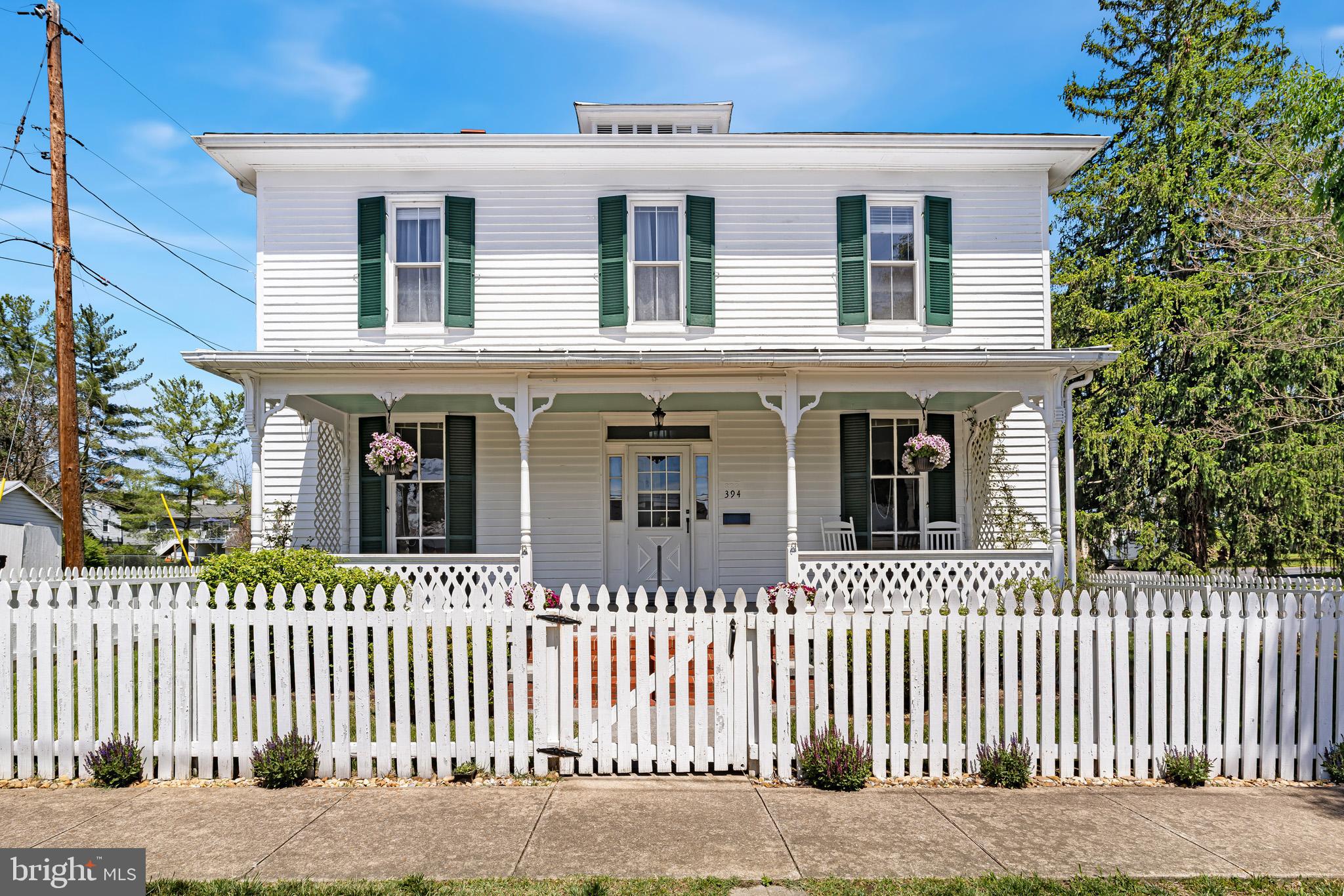 Step into timeless charm at 394 West King Street in Strasburg, VA. This beautiful historic home welcomes you with a classic white picket fence that gracefully wraps around the property, setting the tone for everything inside. Located just minutes from downtown Strasburg, you’ll enjoy easy access to quaint local shops, inviting cafés, and fantastic dining options, all while benefiting from a convenient commuter location near I-81 and I-66. Inside, this spacious home features 4 bedrooms and 2.5 baths, including a convenient main-level bedroom, perfect for guests, flexible living space, or those seeking one-level living options. Rich in character, you’ll find charming details throughout that reflect the home’s historic roots while still offering the space and comfort needed for modern living. A standout feature is the stunning library room, complete with floor-to-ceiling bookshelves and a rolling ladder—an absolute dream for book lovers and a truly unique space to relax or work from home. Out back, the property truly shines. The lovely backyard provides a peaceful retreat, complete with a deck and a screened-in porch—ideal for relaxing evenings, entertaining guests, or simply enjoying the outdoors. A detached one-car garage adds extra storage and functionality. If you’ve been searching for a home with history, charm, and a prime location, this Strasburg gem is one you won’t want to miss.