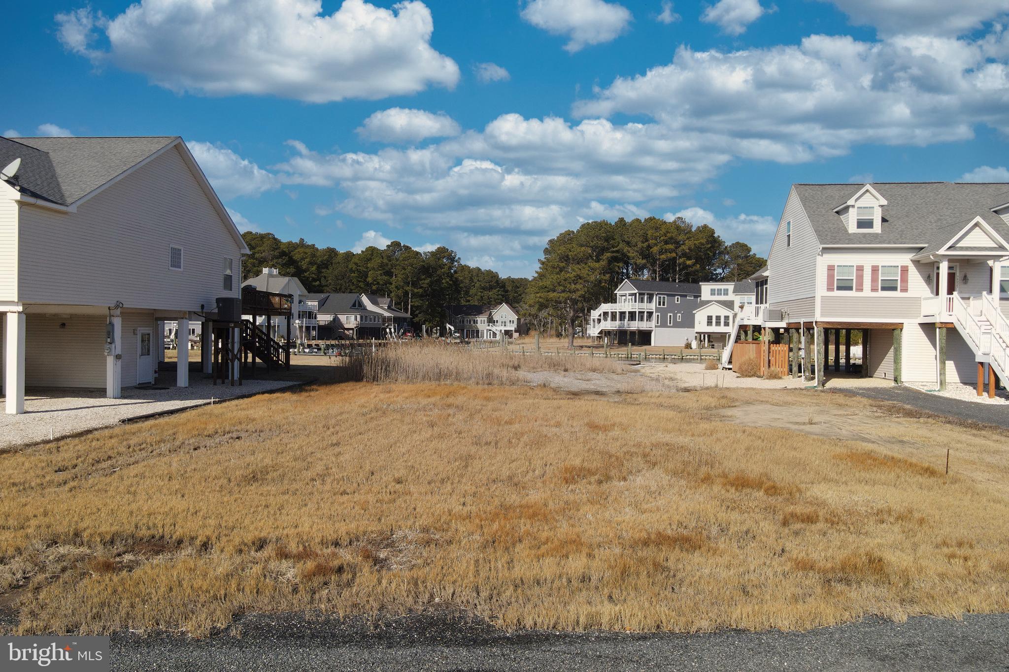 1/935 Oversized (14.373 sq ft), level cleared, canal lot that allows for a larger building footprint over looking the Chincoteague Bay. Take in all the sunrises over the bay. Protected canal front lot that feeds directly into the Chincoteague Bay, come and see for yourself and you will agree! To appreciate the view I encourage you to step outside your car and walk to the back of the lot...PRICELESS!!!! Approx. 60' of Newer Vinyl bulkhead . Great value! HOA amenities: Pristine 9 Hole Golf Course, indoor/outdoor pools (2), fitness center, pickle-ball & basketball courts, playground, boat ramp, picnic area, dog park, biking & walking trails, security and so much more. Call for more information.