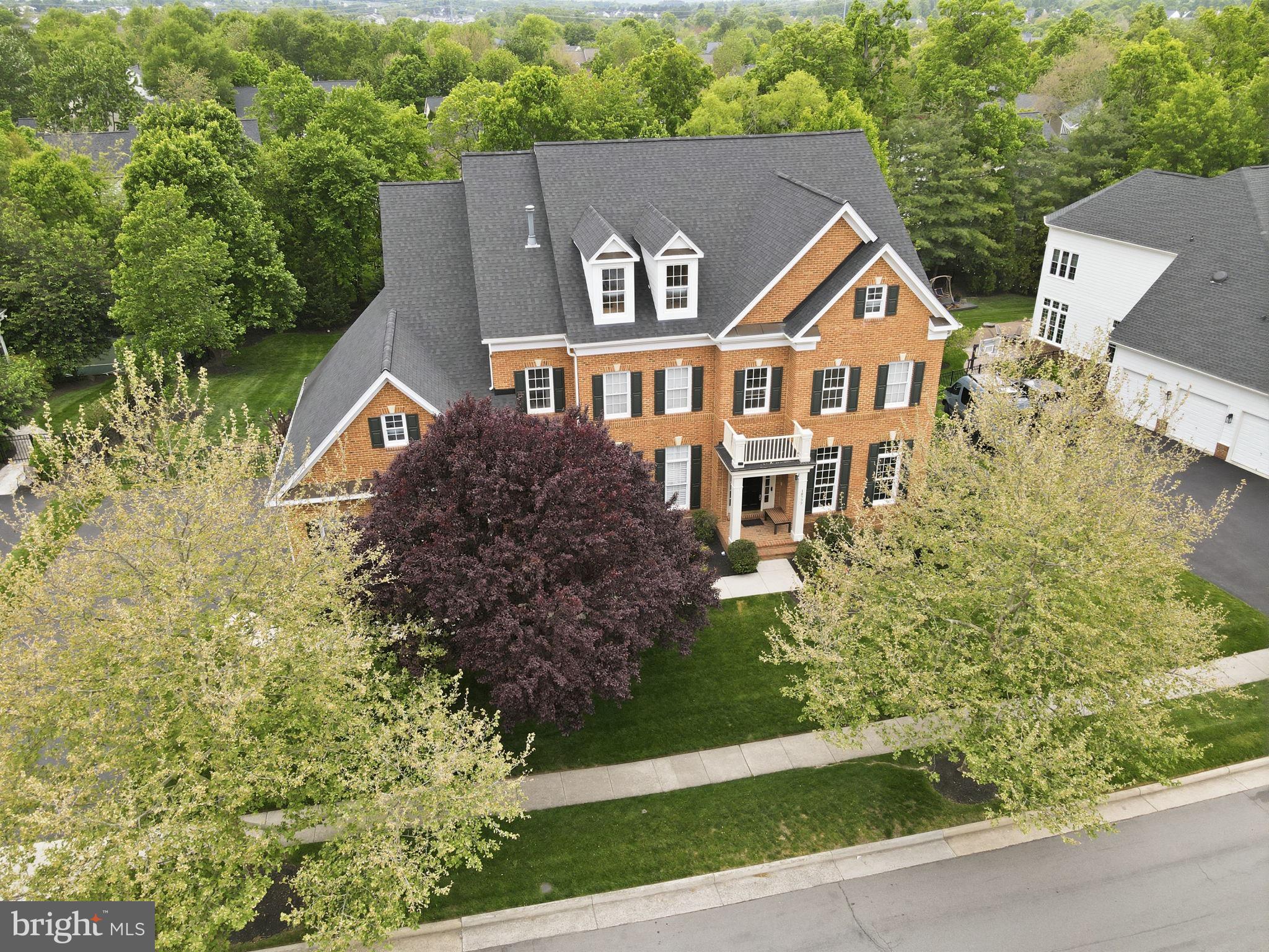 Welcome to an exceptional residence in the sought-after West Goose Creek section of Lansdowne on the Potomac, where space, thoughtful updates, and lifestyle come together seamlessly. Offering nearly 7,000 square feet of finished living space, this impressive home features five bedrooms, five full baths, and two half baths, all set behind a timeless red brick façade and complemented by an expansive, flat, fenced backyard with endless possibilities.  From the moment you arrive, the home’s curb appeal is enhanced by professional landscaping, in-ground irrigation, and elegant exterior lighting.
<br><br>
Enter the main level through an impressive two story foyer that immediately reveals the home’s scale and thoughtful design. Rich hardwood floors, updated designer lighting, and extensive crown molding extend throughout all three levels, while three fireplaces add warmth and character. The main level is both functional and refined, featuring a private home office, an elegant formal living room, and a banquet sized dining room ideal for hosting gatherings of any size. The formal living room is anchored by a two sided gas fireplace shared with the dining room, creating a natural connection between spaces. The kitchen flows seamlessly into the breakfast room and family room, offering an ideal layout for both everyday living and effortless entertaining.
<br><br>
At the heart of the home, the chef’s kitchen is designed for effortless gathering, featuring a spacious island with a prep sink, stainless steel refrigerator, an oversized pantry with a window, and a generous butler’s pantry. The adjacent family room creates a comfortable central hub and flows naturally outdoors to the composite deck, covered porch, and patio below—perfect for relaxing or entertaining on any scale.
<br><br>
Everyday functionality is just as well considered, with a large mudroom complete with built ins, offering the perfect drop zone for shoes, bags, and sports equipment, along with abundant storage throughout the home.
<br><br>
The upper level offers four spacious bedrooms, each with its own private bathroom, as well as a large, separate laundry room for added convenience. The primary suite is a true retreat, featuring a private sitting room, expansive walk in closets with custom built ins, and a beautifully updated bath with a seamless glass shower, dual vanities, granite countertops, and upgraded tile finishes.
<br><br>
The fully finished lower level expands the home’s versatility, offering a bright recreation room, a legal fifth bedroom, a full bath, and a dedicated gym space, making it ideal for guests, extended stays, or everyday living.
<br><br>
A spacious three car garage completes the home, featuring a professionally finished floor and a heavy duty StoreWALL organizational system with panels, shelving, hooks, and racks to keep everything neatly in place. Thoughtful updates include a 2021 roof, 2020 windows, and beautifully updated bathrooms in 2024.
<br><br>
Perfectly positioned for both convenience and lifestyle, the home is just moments from scenic trails and Goose Creek, within walking distance to multiple playgrounds and Winwood, and biking distance to two vibrant town centers. Residents of Lansdowne on the Potomac enjoy an unmatched amenity package, including a year round indoor pool, two outdoor pools, a 30,000 square foot community center, a fitness center with group classes, tennis and pickleball courts, game room, amphitheater with summer concerts, walking trails, parks, and a wide array of clubs and events.
<br><br>
This is a home that truly delivers on space, setting, and lifestyle - designed to be enjoyed at every level.