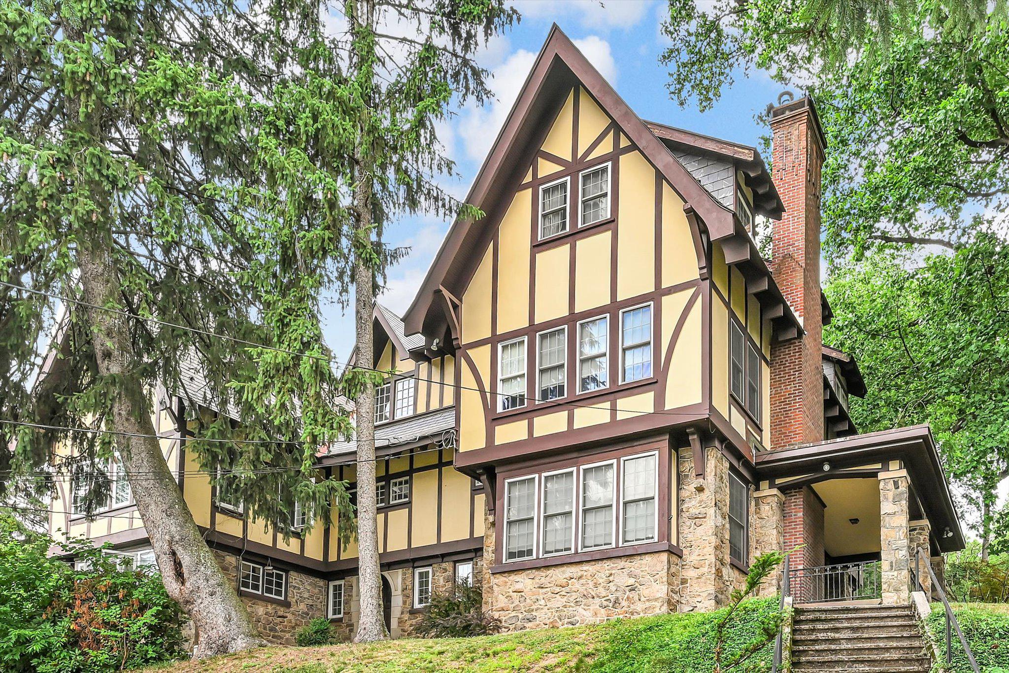 Stately stone Tudor home offering timeless character and plenty of space with 7 bedrooms, 2 full bathrooms, and an additional first-floor toilet. Rich hardwood floors flow throughout much of the home, complementing the classic architectural details and charm. The inviting living room features a fireplace, creating a warm and welcoming gathering space, while the formal dining room is ideal for hosting family dinners and special occasions. The eat-in kitchen provides ample space for everyday meals and entertaining, and the family room offers additional living space for relaxation or recreation. Enjoy the comfort and efficiency of economical gas heat and gas hot water. Recent improvements include the replacement of most of the roof, providing added peace of mind. Outside, the beautiful side porch offers the perfect place to unwind and enjoy the surroundings. This spacious and character-filled home is a rare opportunity for those seeking room to grow and classic Tudor charm.