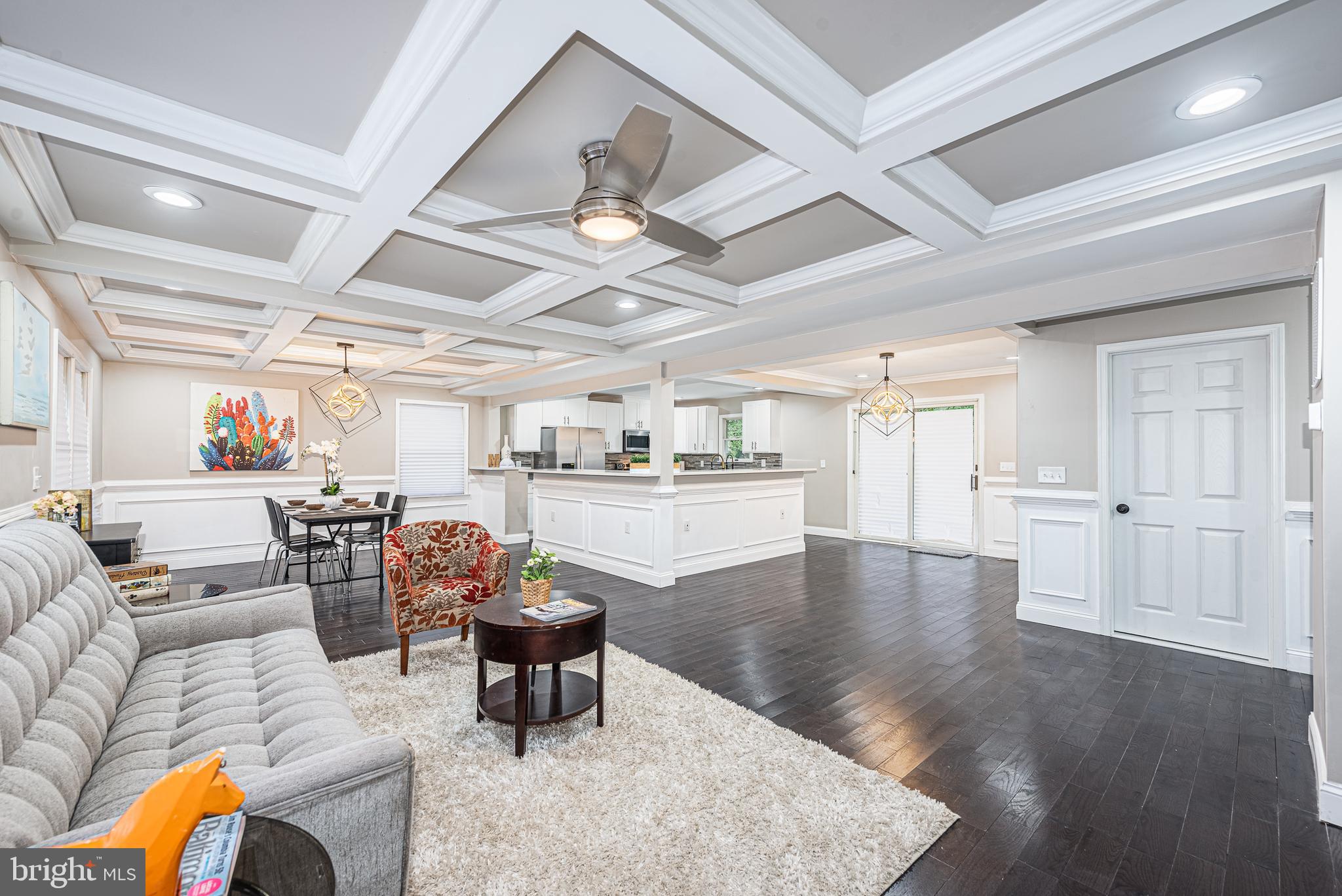 CONTEMPORARY ELEGANCE RADIATES THROUGHOUT THIS BEAUTIFULLY DESIGNED RENOVATION WITH OVER 2,500 SQ. FT. OF LIVING SPACE!  Features include an open floor plan with a spacious living room with a coffered ceiling and an electric fireplace, a convenient main level half bath, a separate dining area with wainscotting, a gourmet island kitchen with Quartz counters & ss appliances, a generously sized Primary suite with a full bath, 2 additional bedrooms on the main level with a hall bath, a fully finished basement with an expansive family room, half bath, and an additional bedroom with a full bath, a large rear deck overlooking the rear yard, and driveway parking for multiple cars!