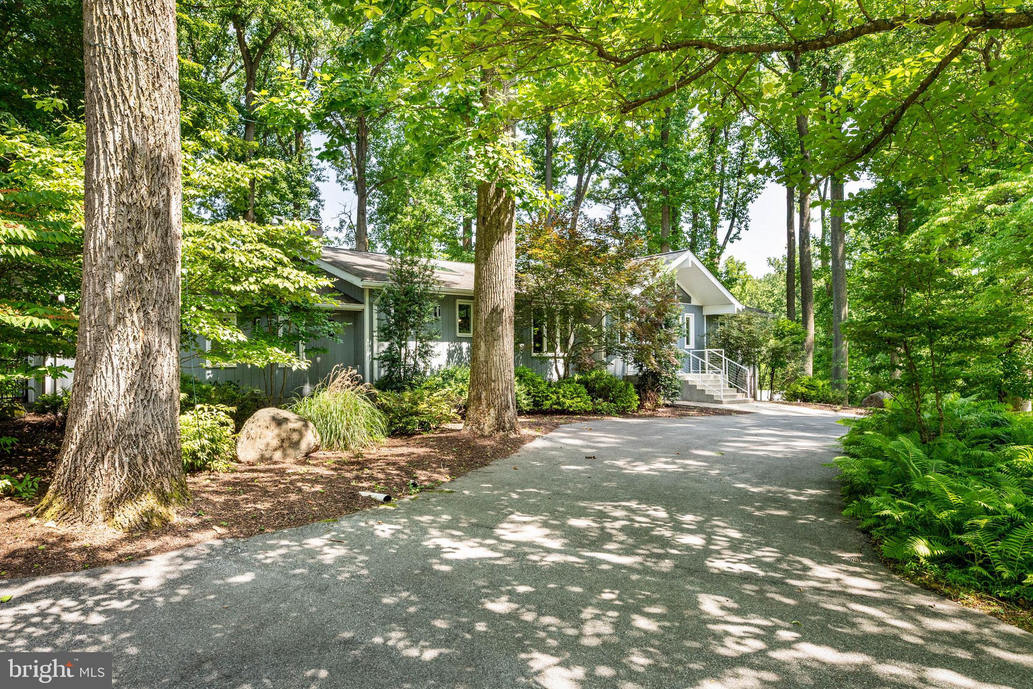 **Welcome to 5 Martins Circle – A Private Mid-Century Modern Retreat on Over an Acre**

Tucked away at the end of a quiet cul-de-sac in the sought-after Greene Countrie neighborhood, this beautifully renovated contemporary home offers the perfect blend of modern design, everyday comfort, and unmatched privacy. Set on approximately 1.26 wooded acres, the property feels like a secluded retreat while remaining just minutes from shopping, dining, Ellis Preserve, Aronimink Golf Club, major roadways, and top-rated  schools.

From the moment you arrive, the dramatic front elevation, soaring glass entry, and mature trees create an unforgettable first impression. Inside, vaulted ceilings, walls of windows, skylights, and recessed lighting fill the home with natural light while showcasing peaceful views in every direction. The living room, dining room, kitchen, office, and primary bedroom and bath all feature soaring vaulted ceilings, enhancing the home's signature Mid-Century Modern architecture.

The thoughtfully updated gourmet kitchen is designed for both entertaining and everyday living, featuring an abundance of custom solid birch cabinetry with a sleek black lacquer finish, premium appliances, double ovens, a wine refrigerator, and two stunning marble-topped islands. One island includes a prep sink and a dramatic double marble countertop, while the adjacent cooktop is complemented by the convenience of a pot filler.

The main-level primary suite offers true one-floor living with beautifully refinished hardwood floors, custom-designed closets, a dedicated shoe closet, and a renovated spa-inspired bath featuring an oversized walk-in shower and heated anti-fog medicine cabinets. A dedicated home office completes the first level.

Throughout the main floor, sliding glass doors with integrated blinds open from the office, dining room, living room, and primary bedroom directly onto the expansive deck, creating seamless indoor-outdoor living. The finished walkout lower level provides exceptional flexibility with additional bedrooms, beautifully updated baths, generous living space, and direct access to the patio through sliding glass doors with integrated blinds from both the family room and utility room. With more than 3,400 square feet of finished living space across the main and lower levels, the home is ideal for guests, multi-generational living, or working from home.

Recent improvements make this home completely move-in ready, including:

* New front entry doors
* Refinished hardwood floors, with hardwood flooring added to the primary bedroom
* Entire interior professionally painted (2020)
* Two custom wood accent walls
* Completely redesigned custom closet systems throughout
* New washer and dryer
* New backyard fencing
* Whole-house propane generator
* Irrigation system
* Professional landscaping and mature tree care

Additional amenities include:

* Two wood-burning fireplaces
* Electric and manual retractable awnings over the deck and patio
* Skylights and recessed lighting throughout
* Sliding glass doors with integrated blinds throughout both levels

Outside, expansive decking overlooks the private backyard, creating an ideal setting for morning coffee, evening gatherings, or simply enjoying the peaceful surroundings beneath a canopy of mature hardwoods.

Modern architecture. Exceptional privacy. Thoughtful updates. A rare opportunity to own one of Newtown Square's most distinctive homes.