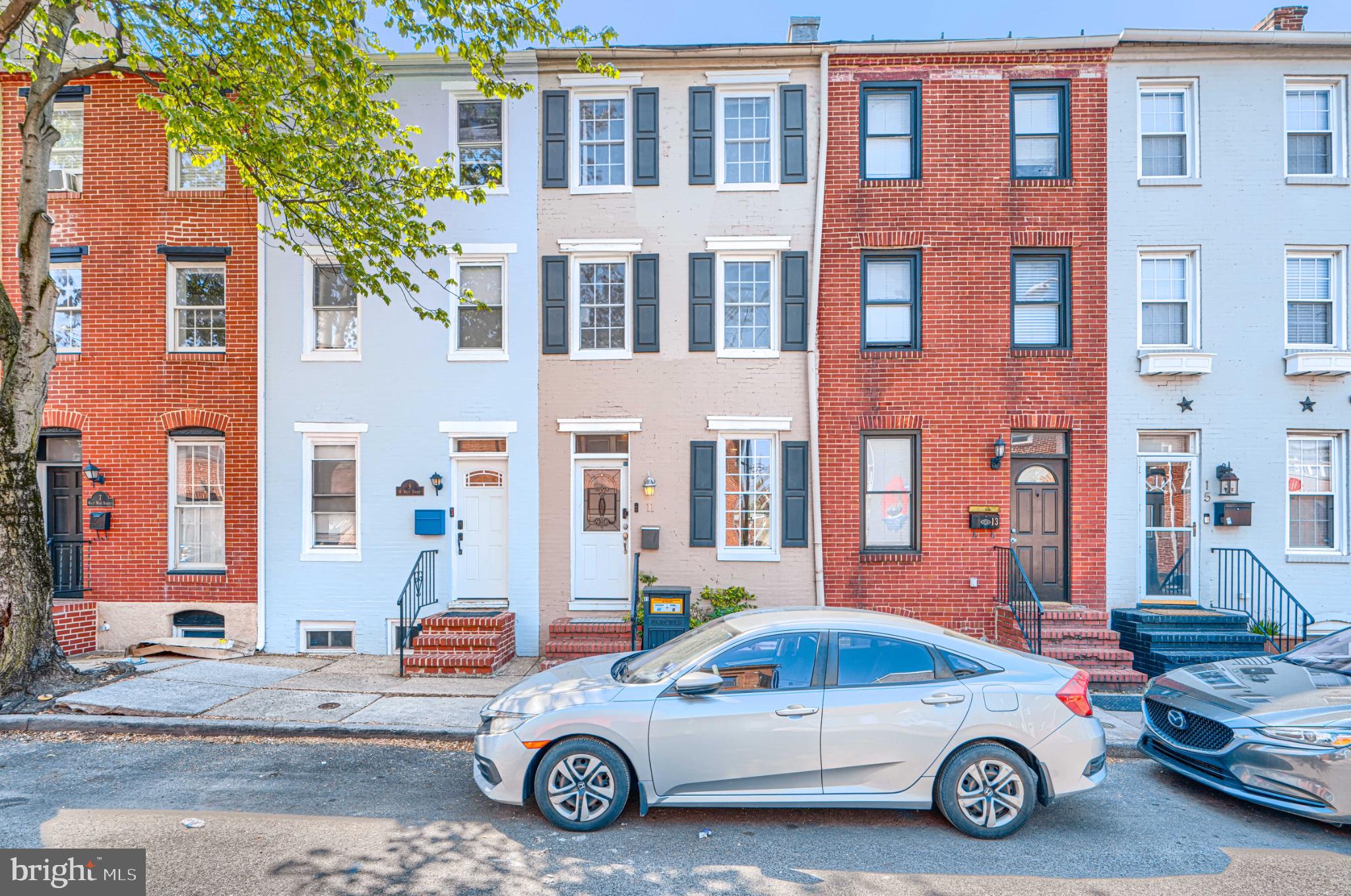 The Heart of Federal Hill: Modern Comfort Meets Rare Convenience
Welcome to 11 W West Street, a meticulously maintained rowhome where historic charm meets modern ease. The main level greets you with a sun-drenched, open-concept floor plan—perfect for entertaining. From the inviting living area to the defined dining space, the flow leads into a gourmet kitchen featuring sleek stainless steel appliances and recessed lighting. A rare rear extension provides the perfect "mudroom" transition to your private outdoor oasis: a true two-car parking pad. In a neighborhood where parking is gold, this is your private sanctuary for summer cookouts and effortless city living.

The upper levels offer ultimate privacy with two expansive primary suites, each boasting its own dedicated full bath. The third floor includes a versatile "bonus" den—ideal for a dream walk-in closet, home office, or nursery. With brand-new HVAC and water heater systems (2026), a bright, storage-ready basement, and the city’s best dining and nightlife just steps away, this home is truly move-in ready.