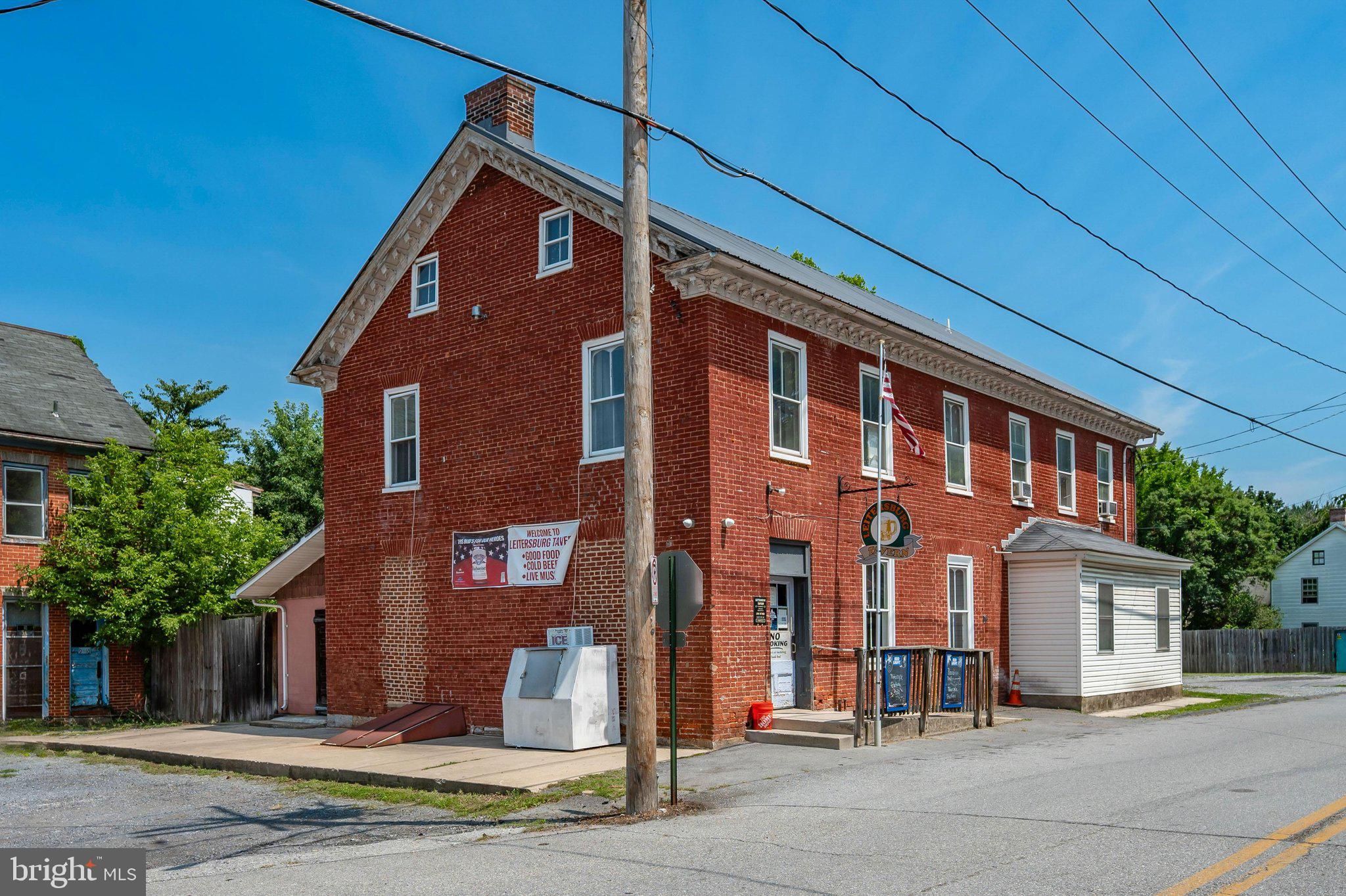 Rare opportunity to own a well-established, TURNKEY tavern and restaurant property in the heart of Leitersburg. Exceptionally clean, well-maintained, and in great condition, this property is ready for its next owner to step in and begin operating immediately.  The sale includes the real estate, business, Class B Liquor License,  all furniture, fixtures, equipment, kitchen equipment, bar equipment, décor, and other business assets currently located on the property, unless specifically excluded by the Seller.  The main level features a spacious bar area, dedicated band and entertainment space, separate lounge area, two restrooms, kitchen, and walk-in cooler.  Step outside onto the covered rear deck overlooking the outdoor entertainment area.  Guests will enjoy the outdoor bar, Tiki Bar, and additional seating areas, creating the perfect setting for dining, live music, special events, and seasonal gatherings.  The second floor offers two income-producing apartments, including a 2-bedroom, 1-bath unit and a 1-bedroom, 1-bath unit, providing additional rental income and investment potential.  The property also offers abundant storage space in both the attic and basement, providing ample room for inventory, equipment, supplies, and business operations.  Ample parking is available in both the front and rear of the property. Whether you're an experienced operator looking to expand an existing operation or an entrepreneur seeking a turnkey hospitality opportunity, this unique property offers multiple income streams and exceptional potential.  Several members of the current staff have expressed interest in remaining with the business, providing the potential for a seamless transition for the new owner, if mutually agreeable.