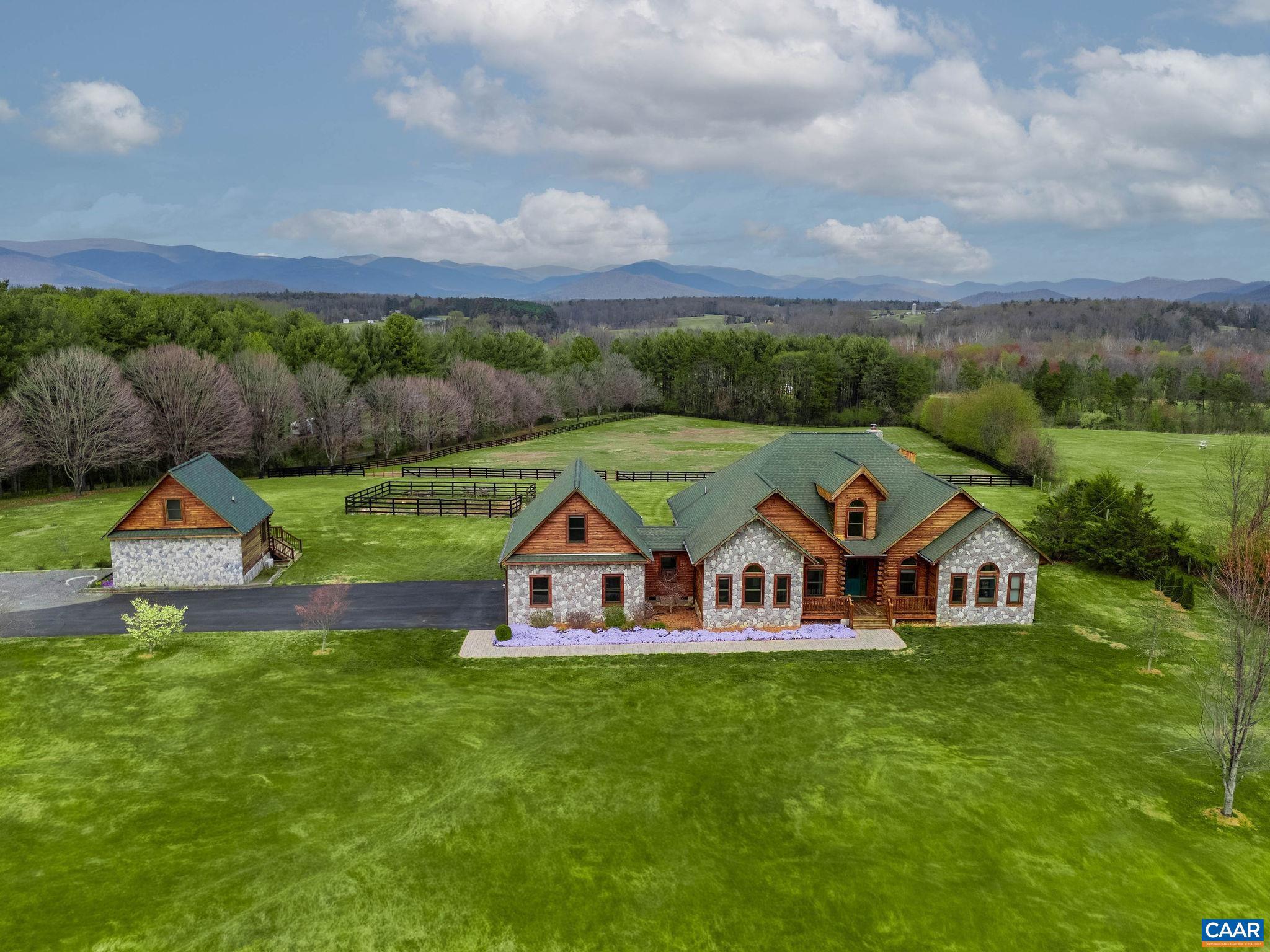 This premier rural retreat offers a total of 5 bedrooms and 4 full baths on 10 open and level acres, including 4 bedrooms and 3 baths in the main home, plus a detached guest cottage with its own bedroom and bath. Set against a backdrop of sweeping mountain views, this luxurious log home offers the kind of setting most people only dream about. The heart of the home is a stunning open-concept great room showcasing dramatic vaulted ceilings with exposed timber trusses and warm tongue-and-groove wood finishes throughout. Floor-to-ceiling windows flood the space with light and frame spectacular mountain views. Rooms are generously sized, and the quality of construction is evident throughout. All the Rocky Top log furniture conveys, as well as everything in the guest house. The guest cottage provides consistent rental income or a perfect private space for visitors. The pastoral 10-acre property is horse-ready with a fenced pasture and run-in shed already in place. Enjoy incredible mountain views from nearly every rear-facing window?an ever-changing backdrop you?ll never tire of. The sellers are offering interest rate buydown funds, with rates as low as 3.375 for Year 1!,Granite Counter,Hickory Cabinets,Fireplace in Great Room