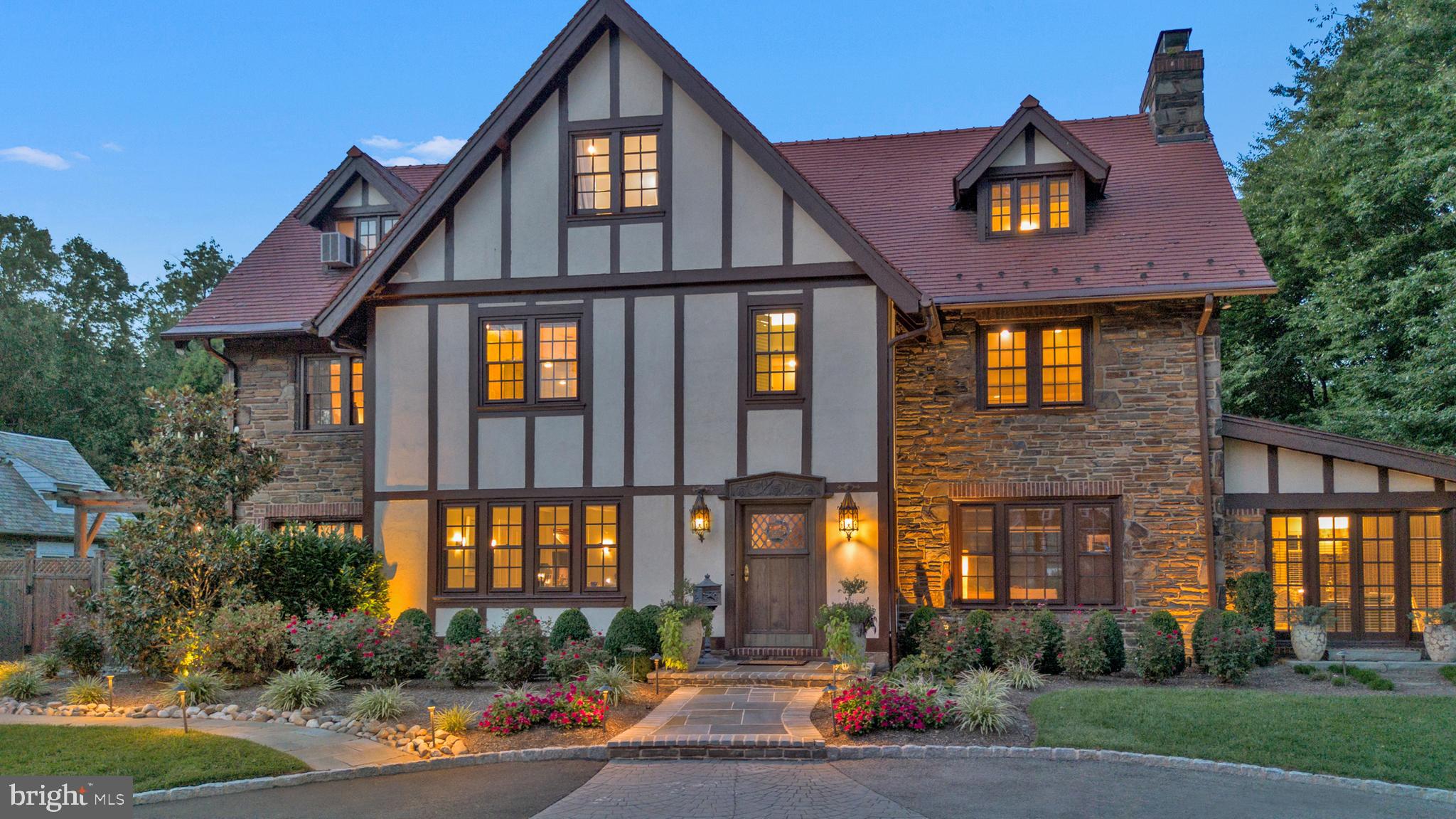 A bargain is available.  We are ready to move, are you? A magnificent Tudor mansion on the mainline is coming to the market. Comprising of 7 bedrooms, 4 bathrooms, 2 half baths, and a separate apartment above the extensive 2 car garage. The home has been lovingly restored and maintained by the current homeowners with many upgrades to add to its natural beauty. Drive up the circular driveway and you’ll notice the amazing landscape with mature trees and a wide variety of shrubs that adorn the entrance. A wealth of lighting has been added to the landscaping to highlight the home in the evening.  Make your entrance via the solid wooden door and be greeted with an open foyer, gorgeous wood floors, a curved staircase, and entrances to the living area and the dining room. The large open living room benefits from a wood burning stove that is surrounded by an ornate mantle and patio doors that lead to a stone terrace overlooking the spectacular back oasis. There’s an additional sitting area that is complete with a wood burning fireplace to add to the natural ambience in the evening. Saunter to the large open dining room and you will see the beautiful, coffered ceiling with sunlight pouring through the large windows. In addition, there is a bonus room that provides an ideal space for casual dining or an area to just relax after a sumptuous meal.  Access can also be gained to a secluded stone terrace. The gourmet kitchen comprises of a wealth of beautiful cabinetry, a subzero refrigerator, a new Miele dual oven with a microwave option and warming drawer. A Fischer Paykel two story dishwasher, granite counter tops, additional large pantry storage cupboards and a double sink complete the kitchen. A back staircase takes you to the second floor.  In the center foyer walk up the stunning curved staircase to find 6 bedrooms and an expansive Owners suite. The suite benefits from a large bedroom with space for all your furniture. There is a large walk -in closet with built-in furnishings to ensure you can organize your belongings. Walk straight through to a luxurious marble bathroom with a separate tiled shower, soaking jetted tub and double vanity. The additional bedrooms provide many options for use. The second floor includes two spacious bedrooms and a Jack and Jill bathroom. The third floor comprises of 4 nicely sized bedrooms and 2 bathrooms, one of which has been recently remodeled to include an extended walk-in shower. There’s an extensive basement with a half bath to complete the home. Recent updates include 4 zone heating and cooling systems that service all floors, whole house wi-fi, and Lutron lighting to name just a few. Outside you will find a tranquil oasis with a large, heated swimming pool and an extensive patio that provides a great space for entertainment and relaxation. A super-sized detached two car garage  includes a studio apartment that comprises of an open plan room with a kitchenette, and a full bathroom with recently added heat and air. Enter the back of your home thru electric gates that ensure your oasis is secure. So many choices for using this whole property. Great location, close to award winning Lower Merion schools, restaurants, shops, major highways and places of worship. Come make your appointment today, you won’t be disappointed. A one year home warranty is being provided for additional peace of mind.