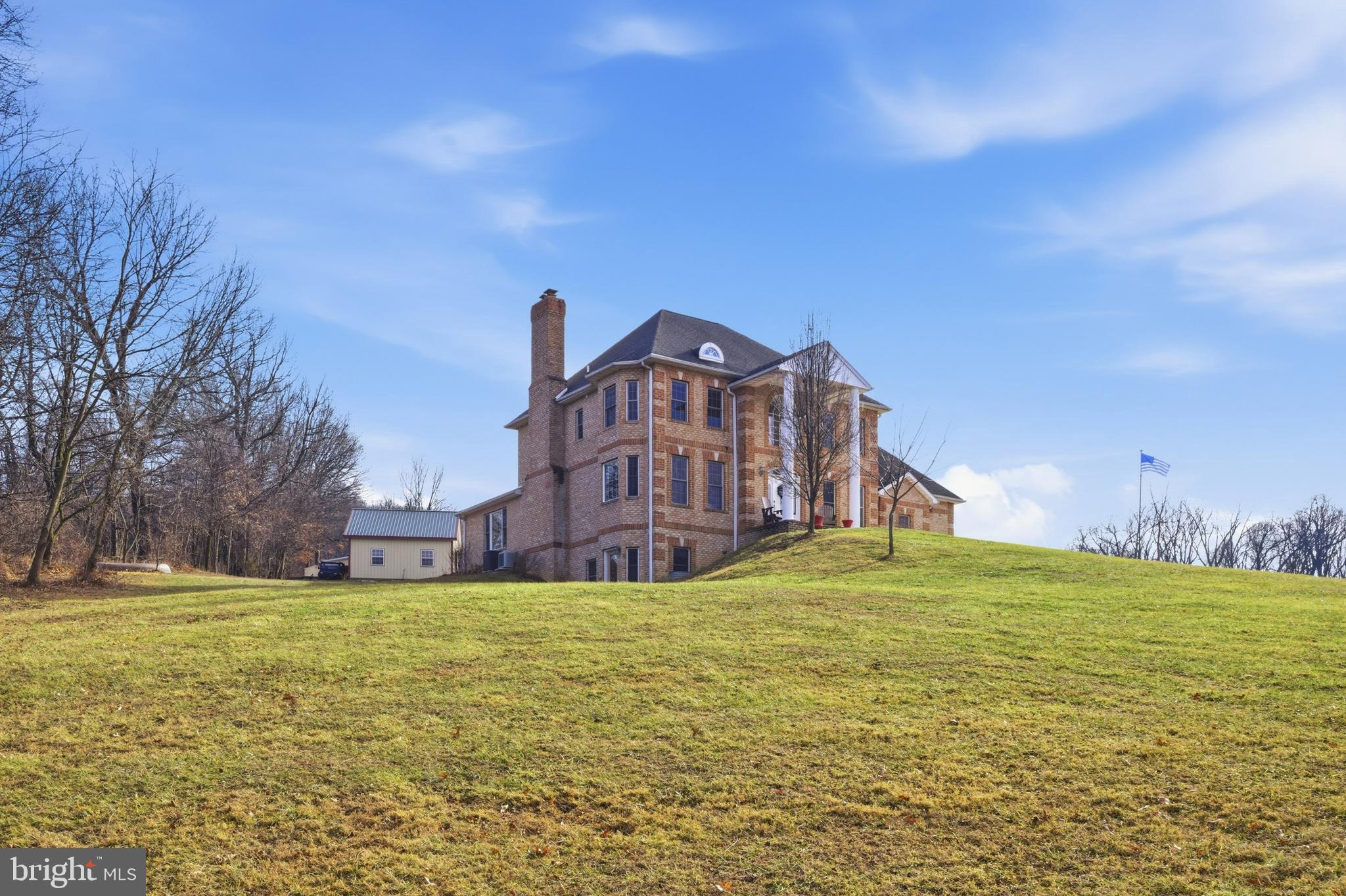 Stately all-brick colonial set on a private, elevated site with spectacular mountain views and million-dollar vistas stretching for miles. Surrounded by scenic countryside and positioned to capture breathtaking panoramic views of the surrounding mountains, this impressive residence sits on over three wooded acres in sought-after Boonsboro, offering exceptional privacy, timeless construction, and an unforgettable natural setting.

The home features a grand colonial layout with expansive, light-filled living spaces designed for both everyday living and entertaining, including a large eat-in kitchen ideal for gatherings and daily living. Two interior staircases add both character and convenience throughout the home. The designer primary bath has been completely remodeled with custom appointments, featuring heated floors, a clawfoot soaking tub, towel warmer, and a spacious walk-in shower. A laundry area on the main level with washer and dryer adds everyday practicality.

A finished walk-out lower level includes one bedroom and a full bathroom, providing flexible space for guests, recreation, or extended living.

Recent improvements and features include updated sensor lighting throughout the home, a water treatment system, stainless bath finishes, and clothing rod stops in closets.

Outdoor amenities enhance the property’s appeal, including two pergolas and a welcoming front porch, both perfectly positioned to take in the sweeping mountain scenery and peaceful surroundings. The property also includes a 24’ x 24’ detached garage with AC and electric, as well as a large barn with electric and a two-car garage component offering exceptional space for storage, hobbies, or workshop use.

This is a rare opportunity to own an all-brick colonial with extraordinary mountain views, extensive improvements, and outstanding privacy in one of Washington County’s most scenic locations.