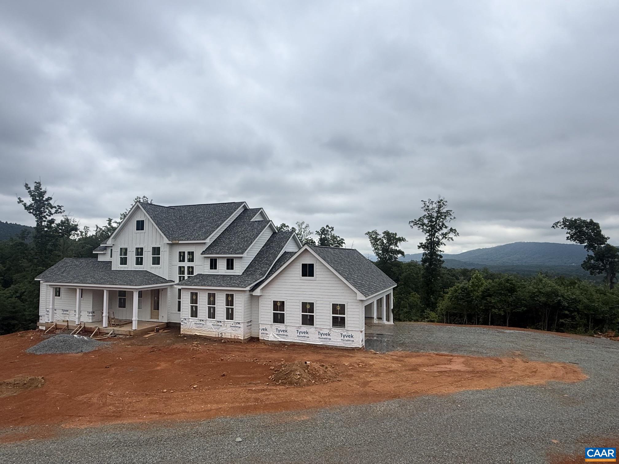 Mountain views less than 10 minutes from downtown Charlottesville, and this is where you come home. Set on over 7 private acres, this striking 5-bedroom, 4.5-bath modern farmhouse blends elevated design with the kind of quiet you can actually feel. A level front yard and welcoming covered porch set the tone before you even step inside.  The open, light-drenched interior delivers quality craftsmanship at every turn. At the heart of the home, a chef's kitchen anchors daily life with a 48" gas range, an oversized island built for gathering, and seamless flow into the soaring 2-story great room where a custom live edge fireplace mantle makes a statement worth slowing down for. Step through to the covered deck and let the mountain views do the rest, year-round and effortlessly.  The first-floor primary suite is a true retreat featuring a spa bath with soaking tub, dual vanities, and an expansive walk-in shower. Upstairs, three generous bedrooms and two full baths offer room for everyone. The walkout basement rounds it all out with a spacious rec room, dedicated guest suite, and full bath ready for whatever you need it to be.,Painted Cabinets,Quartz Counter,Fireplace in Great Room