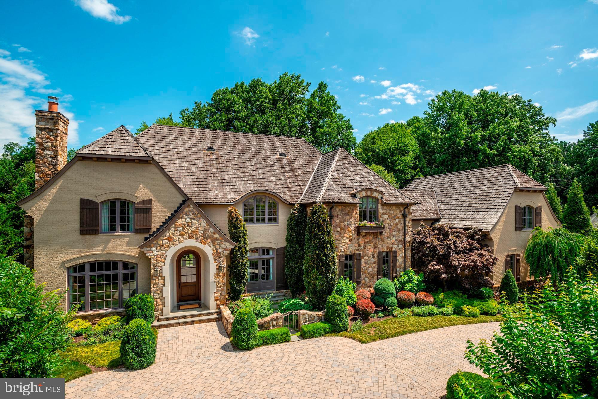 Located in sought after Spring Hill Farm, this custom-built, French Country estate by Artisan Builders, is a one-of-a-kind offering. Featuring beautiful fixtures and finishes throughout its three sumptuously finished levels, including exquisite millwork, salvaged beams and random-width hardwood oak floors, this home is ideal for both grand entertaining and day-to-day family living. Minutes to both the Dulles Toll Road and the Capital Beltway, it's an easy commute to Tysons, Washington, DC and Bethesda. The Main Level offers an elegant Foyer, flanked by the Living Room with a fireplace that has a limestone mantel and the formal Dining Room with hand-painted paneled walls and French doors leading to a gated patio with custom iron gate. A Butler's Pantry leads to the gourmet Kitchen with a large center island that has honed granite and quartz countertops, top-of-the-line appliances including a Wolf cooktop with a grill, double convection wall ovens, a SubZero refrigerator and freezer, two Bosch dishwashers and a Sharp drawer microwave. The Kitchen opens to a Breakfast Area and a light-filled Family Room with gorgeous salvaged beams, a gas fireplace and French doors leading to the covered Terrace and lush backyard. The Library with custom built-ins, Home Office by the Kitchen, two Powder Rooms, a Mudroom providing access to the private in-law/au pair suite and attached three-car Garage complete this level. The Second Level the Master Suite features an expansive bedroom with built-ins, his-and-her walk-in closets and a Master Bath with dual vanities, a jetted tub and separate shower. Additionally there are three more en suite Bedrooms, each with beautifully appointed baths and walk-in closets, a built-in study area and Laundry Room. The private Guest Suite with separate staircase off of the mudroom, there is an in-law/au pair suite with a spacious Bedroom, Sitting Room and full Bath. The Lower Level offers a Recreation Room opening to a Game Room, a convenient gift wrapping room, a Bedroom Suite that is currently configured as an exercise room with an en suite Bath, a Powder Room and a large storage/utility room. The stunning grounds feature beautiful hardscape and verdant landscaping with mature trees and gorgeous plantings. There is a large Loggia with extensive stone terraces that includes an outdoor fireplace and a separate area off of the kitchen and family room that is ideal for outdoor dining and entertaining!