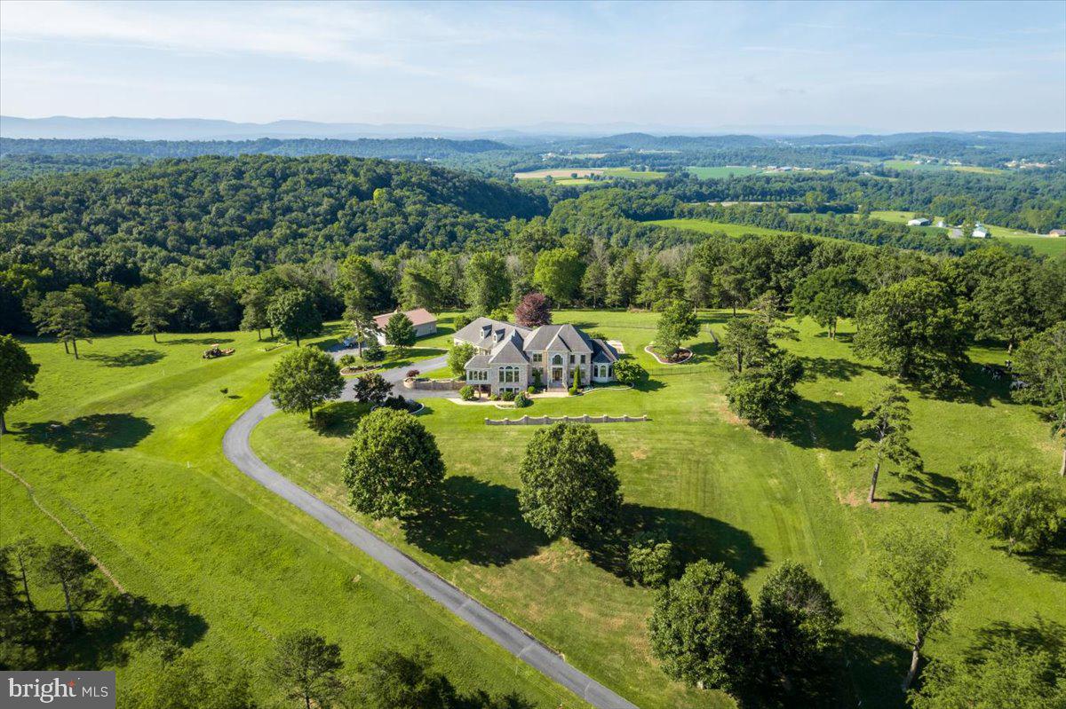 Notre Reve: "The Castle on the Hill - Our Dream." The pinnacle and crowning point of North River.  Sixty four bucolic acres with mesmerizing panoramic views. The best of everything. Superb workmanship and splendid design by Gary Crummett. Preeminent, respected master craftsman is reflected within this well-planned expansive, delightful home. Description is insignificant for the beauty of the land, the views and home. One can stand in the kitchen and see in four directions--all with a view. Splendid detail throughout and rich traditional color palette. You will find: A gallery, gourmet family kitchen, great room, sunroom, dining, and living, primary suite on main floor, and an office wing, mud room, service kitchen, large laundry suite. Lower walkout level with apartment and full kitchen and great room. The detail and built-in features alone will take your breath away. The pool, veranda, and shade portico to enhance your living.  Plethora of storage. Safe room. Solar providing 50% net metering. 3-bay garage/workshop. Agricultural building. Potential of more acreage.