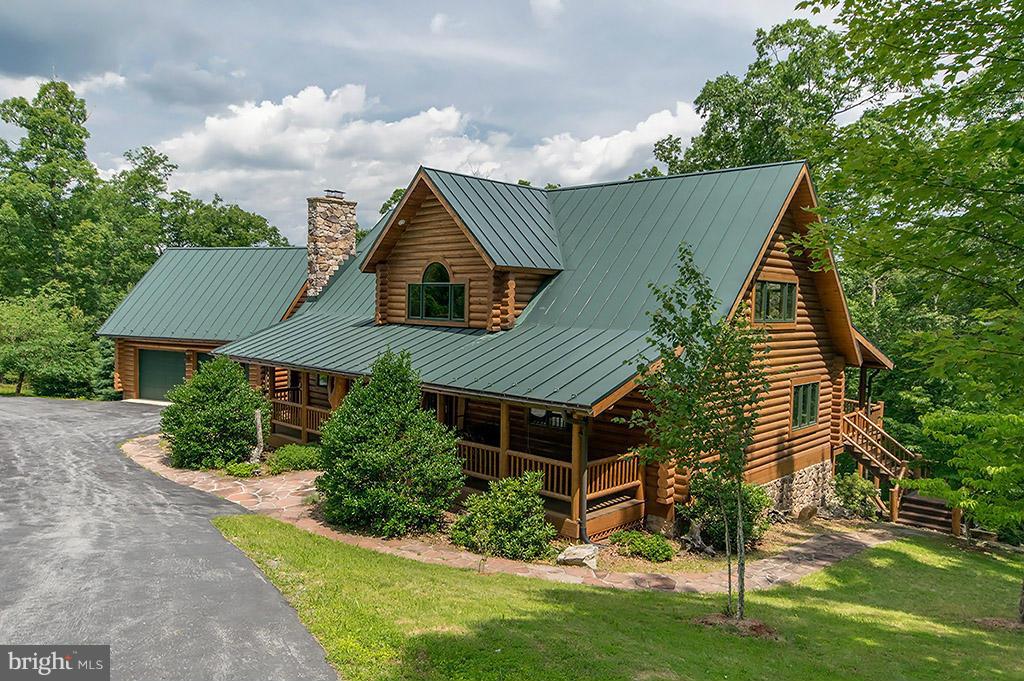 DRASTIC REDUCTION! Custom-built Log home on 10+  acres that features all hardwood floors, cathedral ceilings, Colorado slate, stone fireplaces, woodstoves, Colorado Tile breakfast bar, loft/library with built-in bookcases ,deck with hot tub and 2 covered areas, lower level w/family room, office, bedroom, weight room and covered stone patio, 3 car garage, breezeway, woodshed, creek, and more!