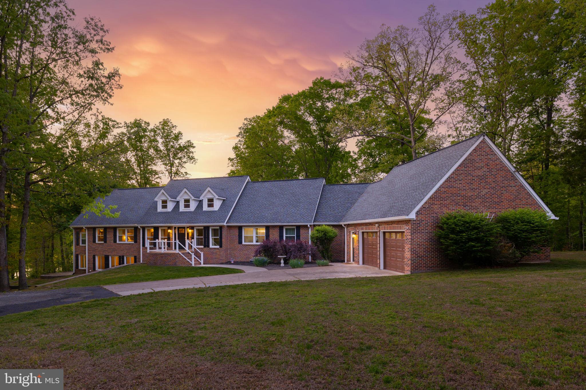 Set on 3.53 acres with 280 feet of deep water frontage on the public side of Lake Anna, this exceptional waterfront retreat in the gated Kelly’s Landing community delivers the ultimate lake lifestyle with unforgettable views. A concrete walkway leads to your private covered boathouse, complete with a sun deck, storage, double jet ski pad, and a waterfront gazebo—perfectly designed for long summer days on the water. An additional observation deck offers a front-row seat to breathtaking sunsets, creating an ideal setting for gathering, relaxing, and making lasting memories. This custom-built Vermont Timber Frame home, fully furnished and thoughtfully renovated in 2019, spans over 6,100 finished square feet across three levels with an open, light-filled design. Soaring 21-foot vaulted wood and beam ceilings anchor the main living space, while the chef’s kitchen impresses with an oversized 8x6 Carrara marble island, stainless steel appliances, and a walk-in pantry with integrated laundry. The lakeside primary suite offers direct deck access, vaulted ceilings, dual walk-in closets, and jetted tub and double vanity. A spiral staircase leads to a loft overlooking the main level, along with an additional bedroom and private bath. The walkout lower level is built for entertaining, featuring a spacious family room, separate recreation area with pool table, four additional bedrooms and two baths. Outdoor living is equally inviting, with a lakeside deck, dining gazebo, grilling area, and a patio with fireplace, plus a covered swing for quiet moments. Currently operating as a successful short-term rental with $160,000 in income in 2025, this turn-key property presents a rare opportunity for both personal enjoyment and investment. Whether hosting large gatherings or enjoying peaceful lake days, this home offers a lifestyle that brings people together in the best way. Located less than 2 hours from Washington, D.C., this home is perfect for even a quick weekend trip to get away and relax. Enjoy close proximity to local dining and favorites like Tim’s at Lake Anna, Moo-Thru for ice cream and mini golf, The Cove restaurant, and nearby marinas.