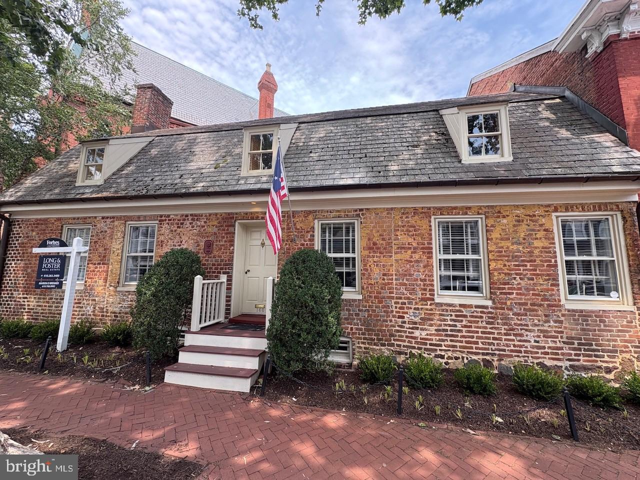 RARE OPPORTUNITY TO OWN A REMARKABLE PIECE OF ANNAPOLIS HISTORY! The Patrick Creagh House c. 1740 (also known as 160 Prince George Street) is an architecturally significant residence with a gambrel roof structure and features header and English bond brick walls. This property has been thoughtfully adapted for modern living while preserving its timeless character and craftsmanship. Ideally located in the heart of Annapolis just one block from the US Naval Academy Gate 1, City Dock, Main Street and the Maryland State House, this exceptional home offers the best of historic charm and downtown convenience. A welcoming center hall introduces spacious living and dining rooms designed for both elegant entertaining and comfortable everyday living. The private patio and garden create a serene outdoor extension of the home’s living spaces. Upstairs, the home features a primary suite with full bath, two additional bedrooms, a second full bath, and convenient laundry. The lower level provides ideal space for a wine cellar, storage, or additional utility needs. The property’s kitchen, baths and wiring have been updated and the home is move-in ready! This distinguished 18th-century property has been extensively researched and documented and is listed on the NATIONAL REGISTER OF HISTORIC PLACES for its architectural importance and contribution to local history. Patrick Creagh was a man of many skills and was considered an important person in the community. He is mostly known for building the Old Treasury c. 1737 on the Maryland State House Grounds, the oldest public building in the state that was fully restored and opened to the public this year.  Seller is offering a credit to buyer for parking garage fees - ask listing agent for more information.